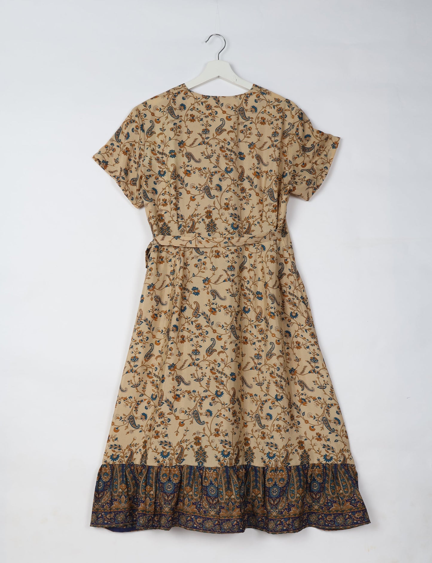 Embrace timeless elegance with our MIDI WRAP DRESS – a midi-length beauty featuring a v-neck, flattery from all angles, and a charming sari belt. Crafted from sustainable materials, this dress embodies ethical clothing and green fashion. Sophisticated with a frill tier at the hem and short cap sleeves, this dress is perfect for any occasion. Tie up the beautifully crafted sari belt on the side for a versatile, stylish, and eco-friendly look.