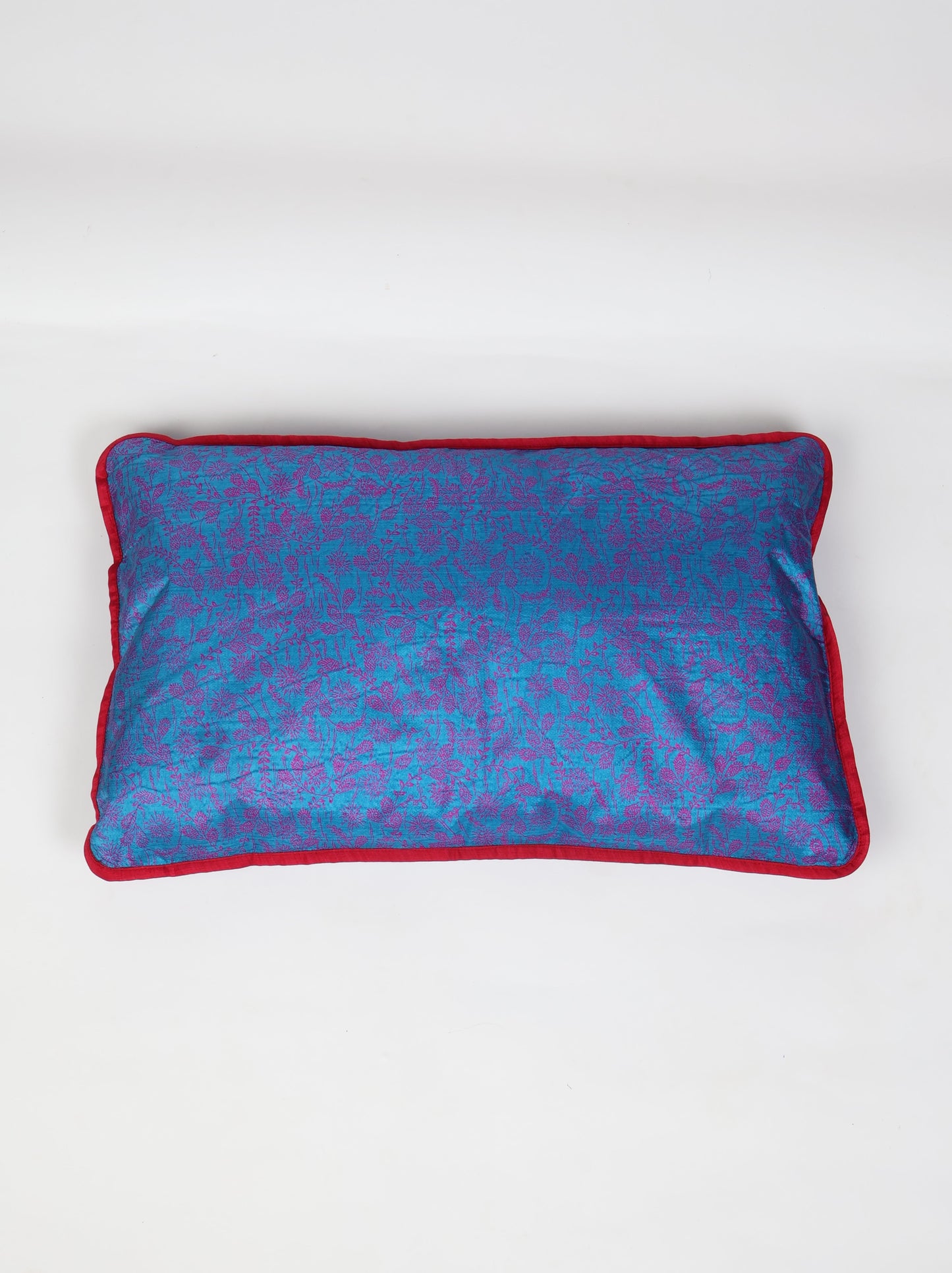 An eco-friendly Lumbar Cushion Cover with piping edge made from recycled saris. Featuring a stylish five-button closure, this sustainable fashion piece highlights upcycled women's clothing, eco-friendly cloth, carbon-neutral fashion, and natural clothing. A beautiful recycled sari product promoting climate-neutral and environmentally friendly clothing.