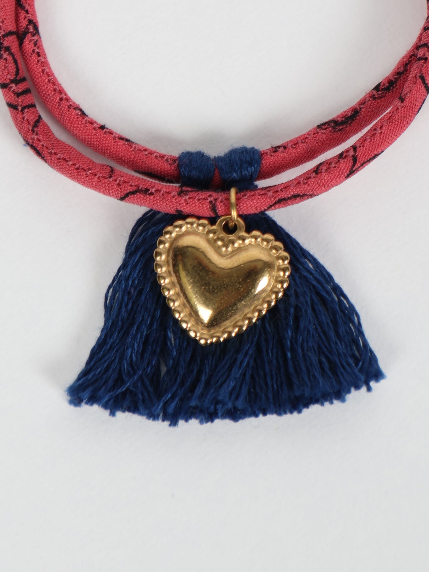 Handmade rope bracelet from recycled sari fabric with gold heart charm and tassels—eco friendly cloth, climate neutral fashion, and upcycled women’s clothing.