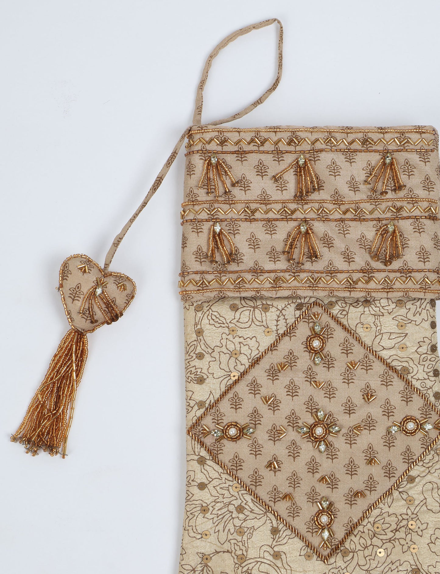 Ivory and cream upcycled sari Christmas stocking with gold hand embroidery, patchwork detailing, and a beaded heart charm tassel — crafted from recycled materials and inspired by circular, fair trade, and eco clothing fashion.