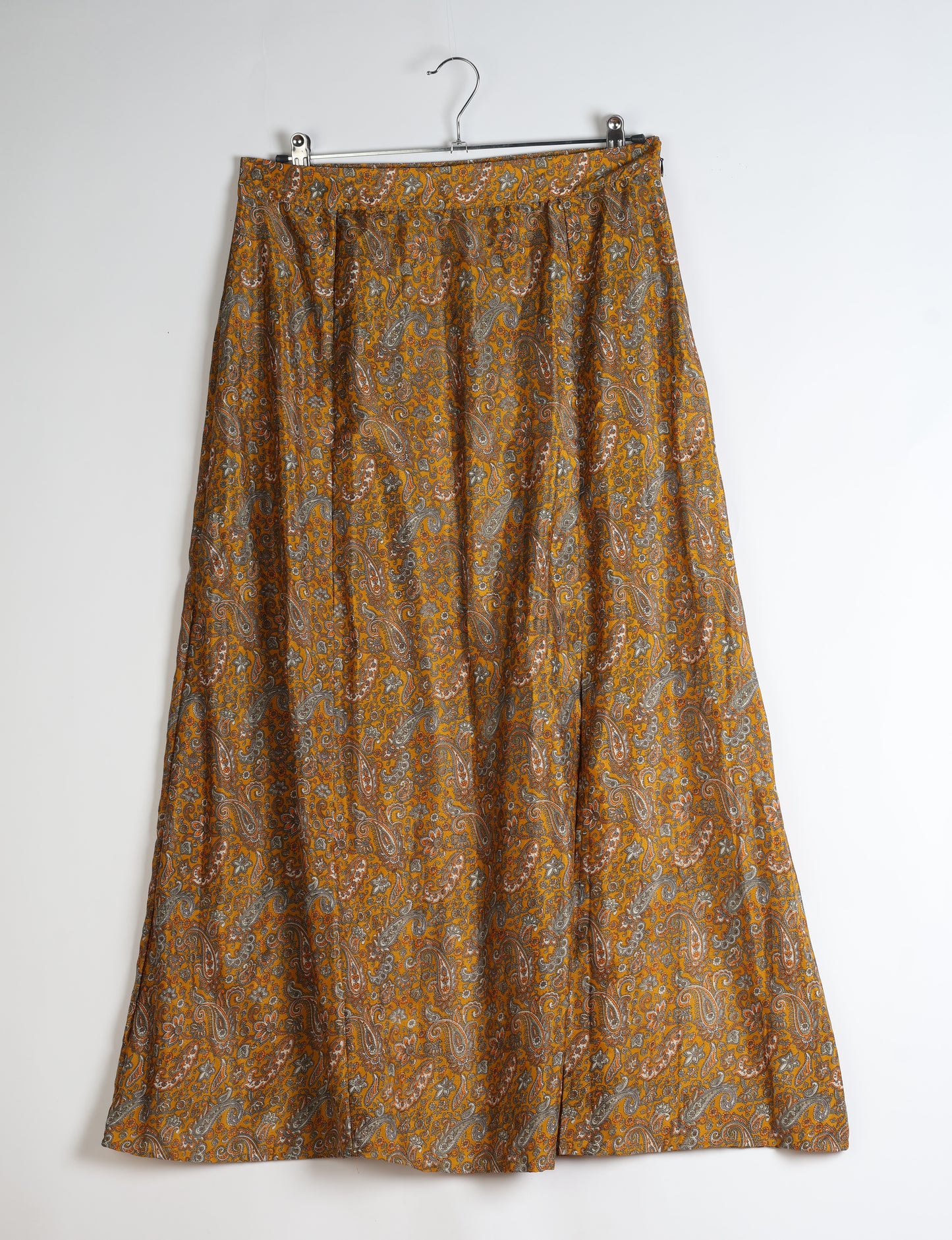 Midi A-line skirt with front slit, fitted waistband, concealed side closure, and below mid-calf length silhouette.