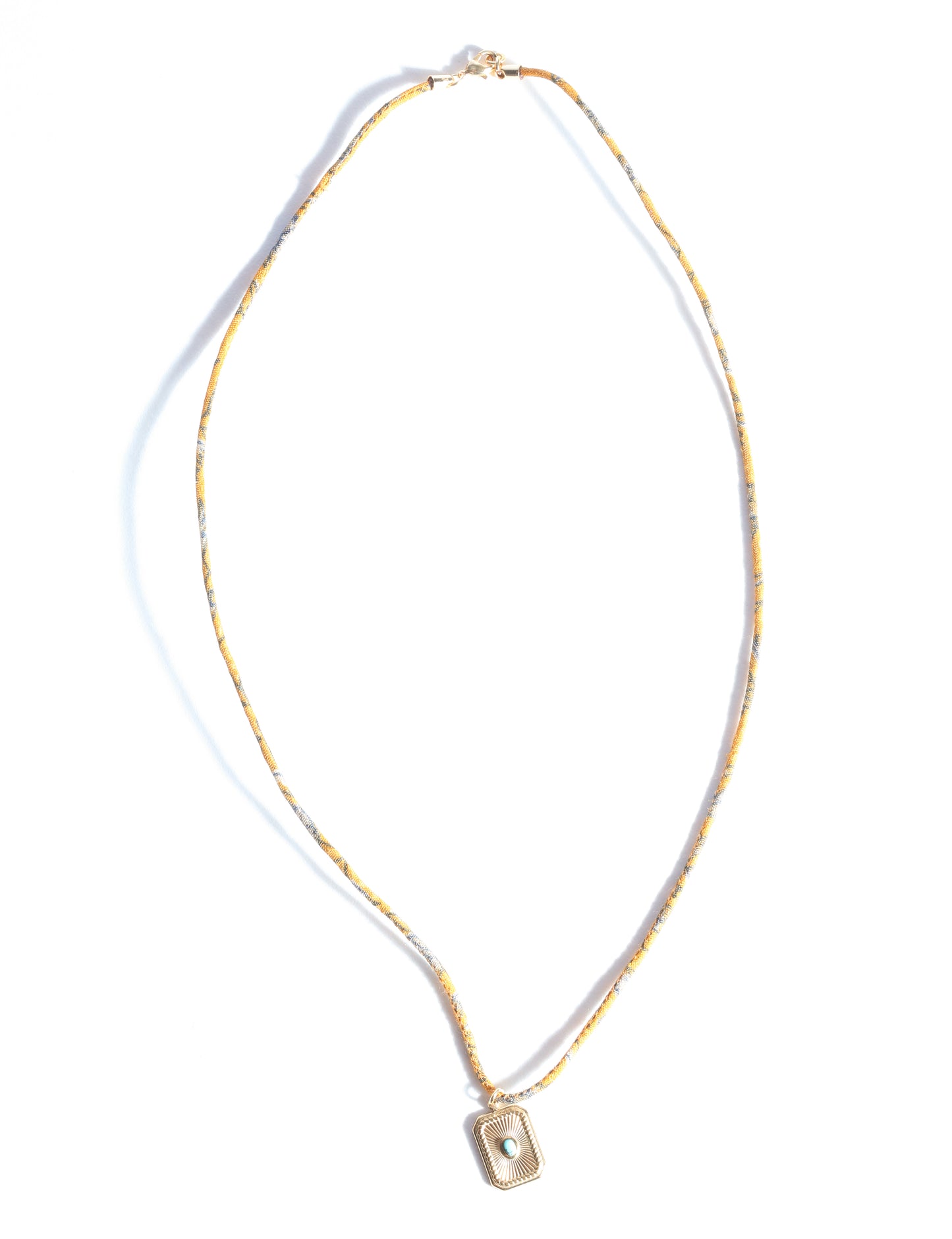 Adjustable cord necklace with gold-plated metal pendant inspired by upcycled women’s clothing, sustainable women’s clothing, eco friendly fashion, recycled sustainable fashion, carbon neutral fashion, and environment friendly clothing principles.