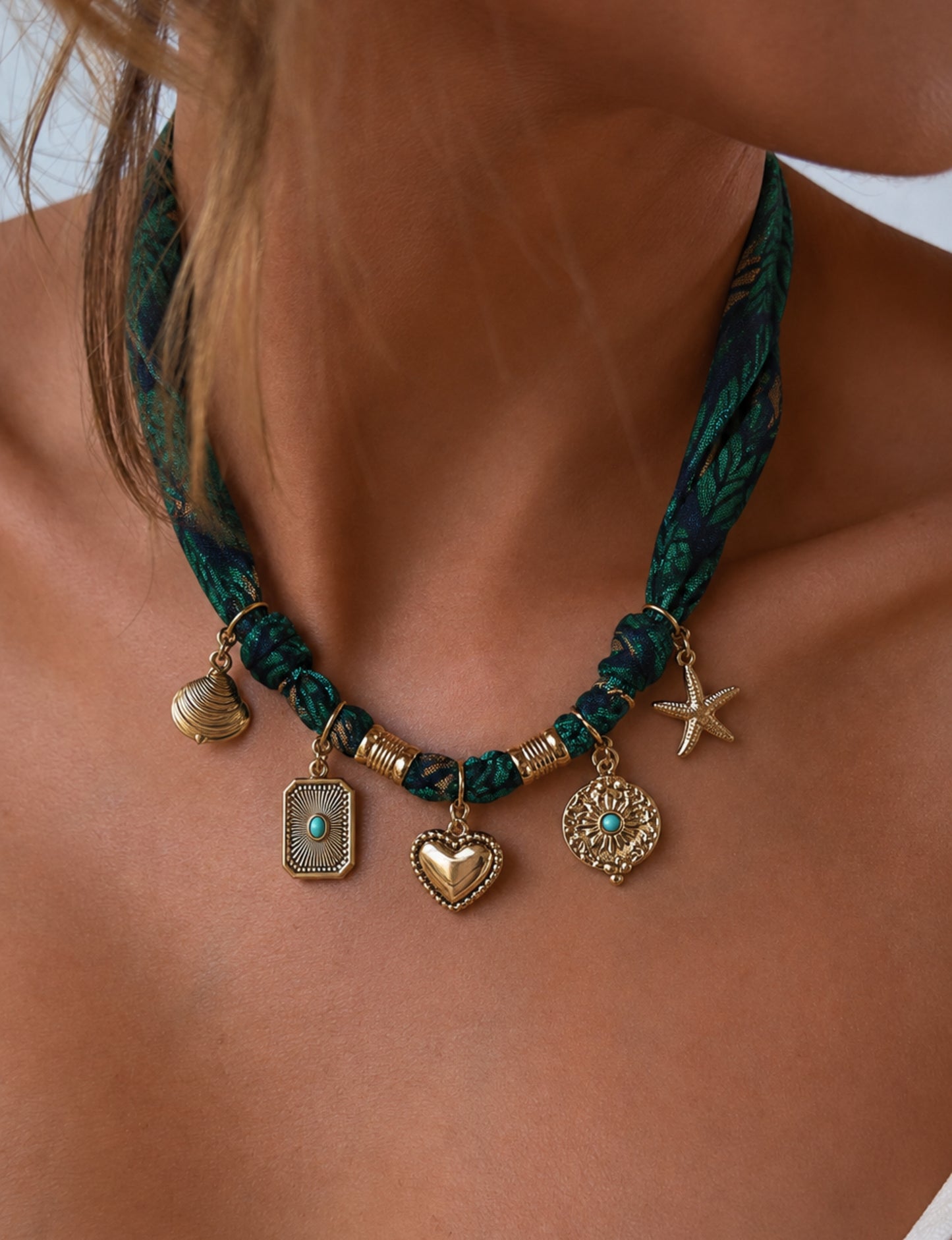 Bandana necklace with gold-plated charms, adjustable tie-back design, stainless steel hardware, handmade statement necklace, sustainable fashion accessory.