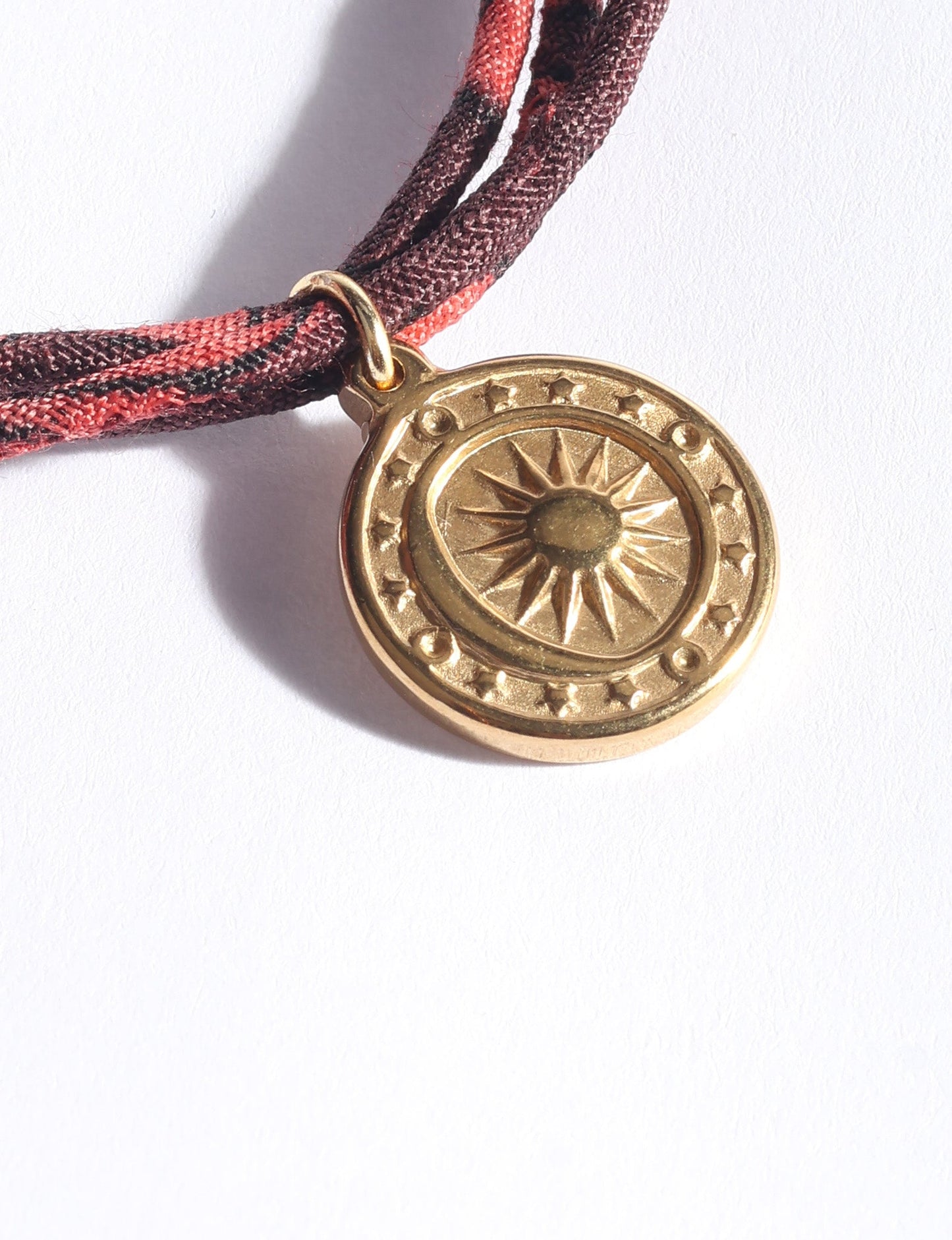 Slim adjustable cord bracelet with gold-plated stainless steel sun charm, inspired by upcycled women’s clothing, sustainable women’s clothing, eco friendly fashion, recycled sustainable fashion, carbon neutral fashion, and environment friendly clothing values.