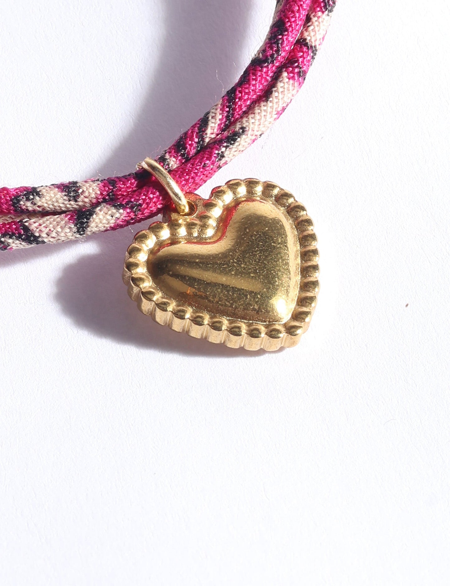 Slim adjustable cord bracelet with gold-plated stainless steel heart charm inspired by upcycled women’s clothing, sustainable women’s clothing, eco friendly fashion, recycled sustainable fashion, carbon neutral fashion, and environment friendly clothes values.