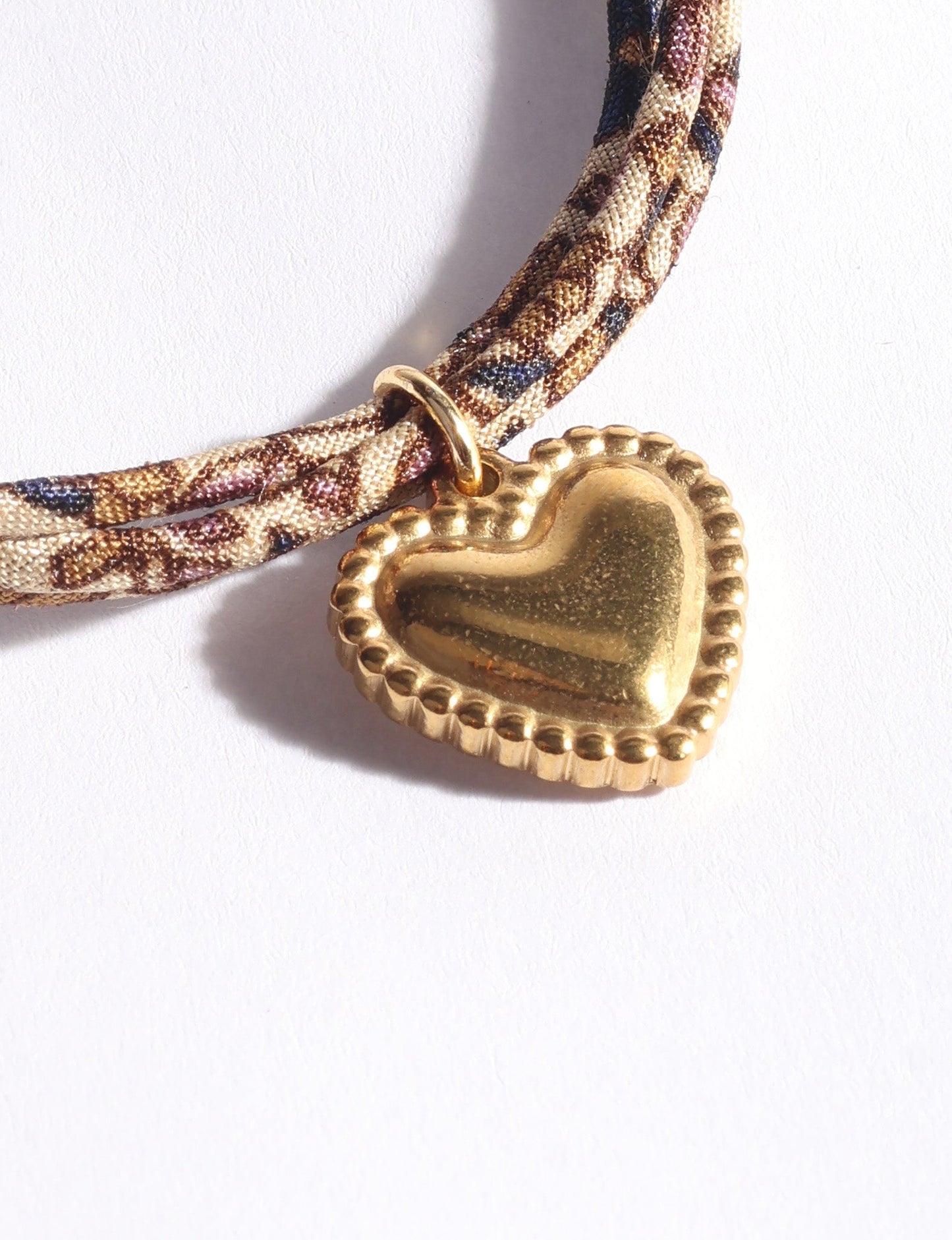 Slim adjustable cord bracelet with gold-plated stainless steel heart charm inspired by upcycled women’s clothing, sustainable women’s clothing, eco friendly fashion, recycled sustainable fashion, carbon neutral fashion, and environment friendly clothes values.