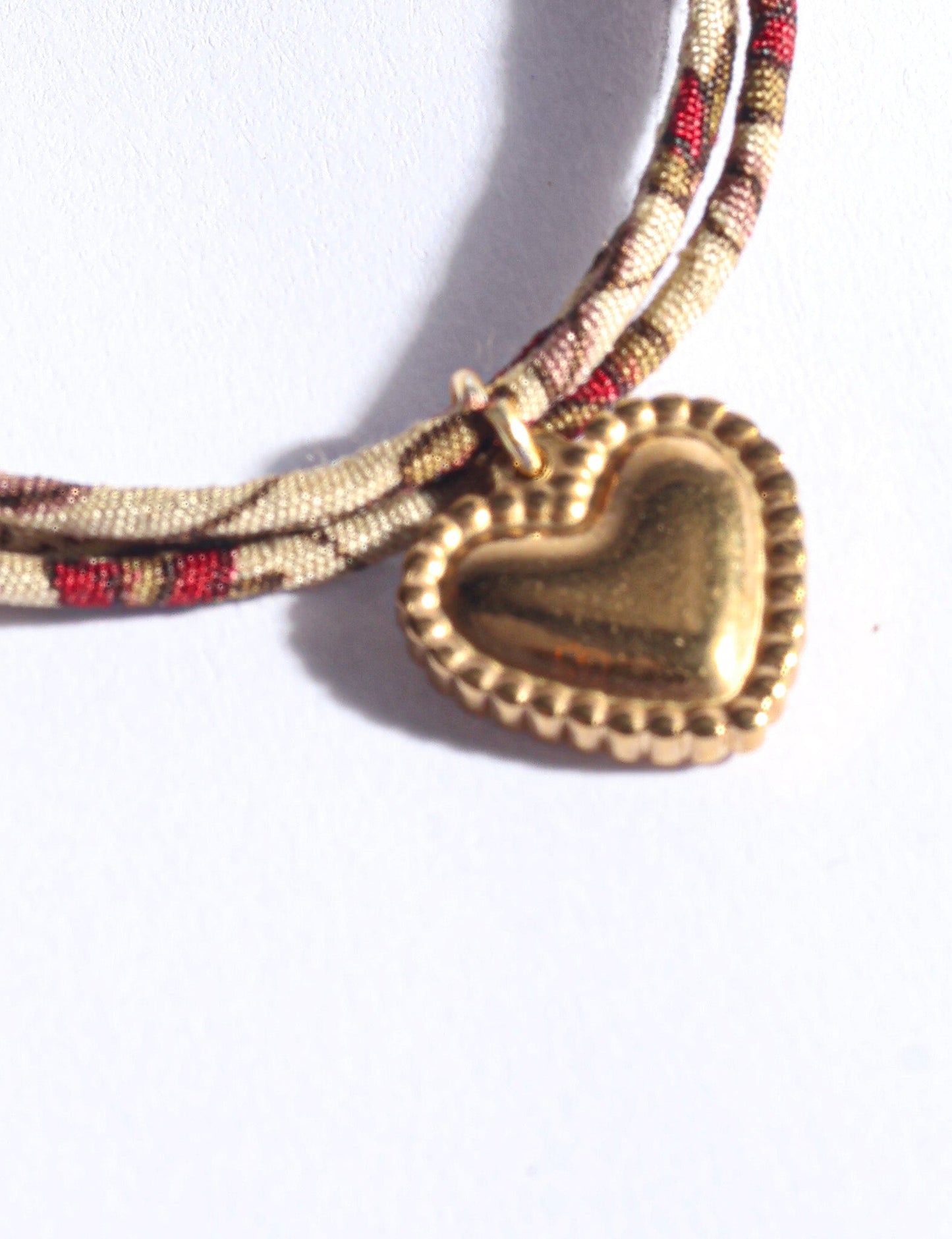 Slim adjustable cord bracelet with gold-plated stainless steel heart charm inspired by upcycled women’s clothing, sustainable women’s clothing, eco friendly fashion, recycled sustainable fashion, carbon neutral fashion, and environment friendly clothes values.