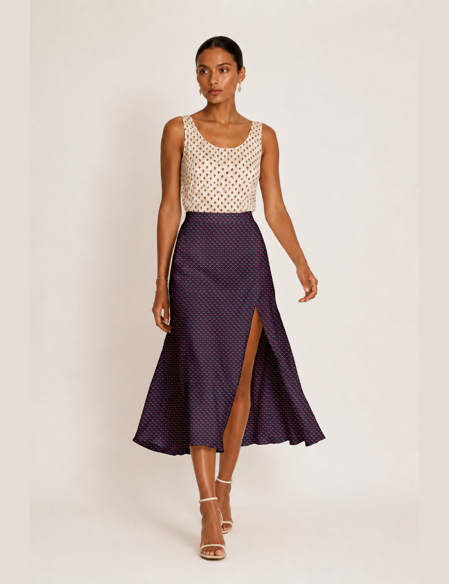 Woman wearing a yellow and black micro patterned A-line skirt with front slit, paired with beige sleeveless top and black
