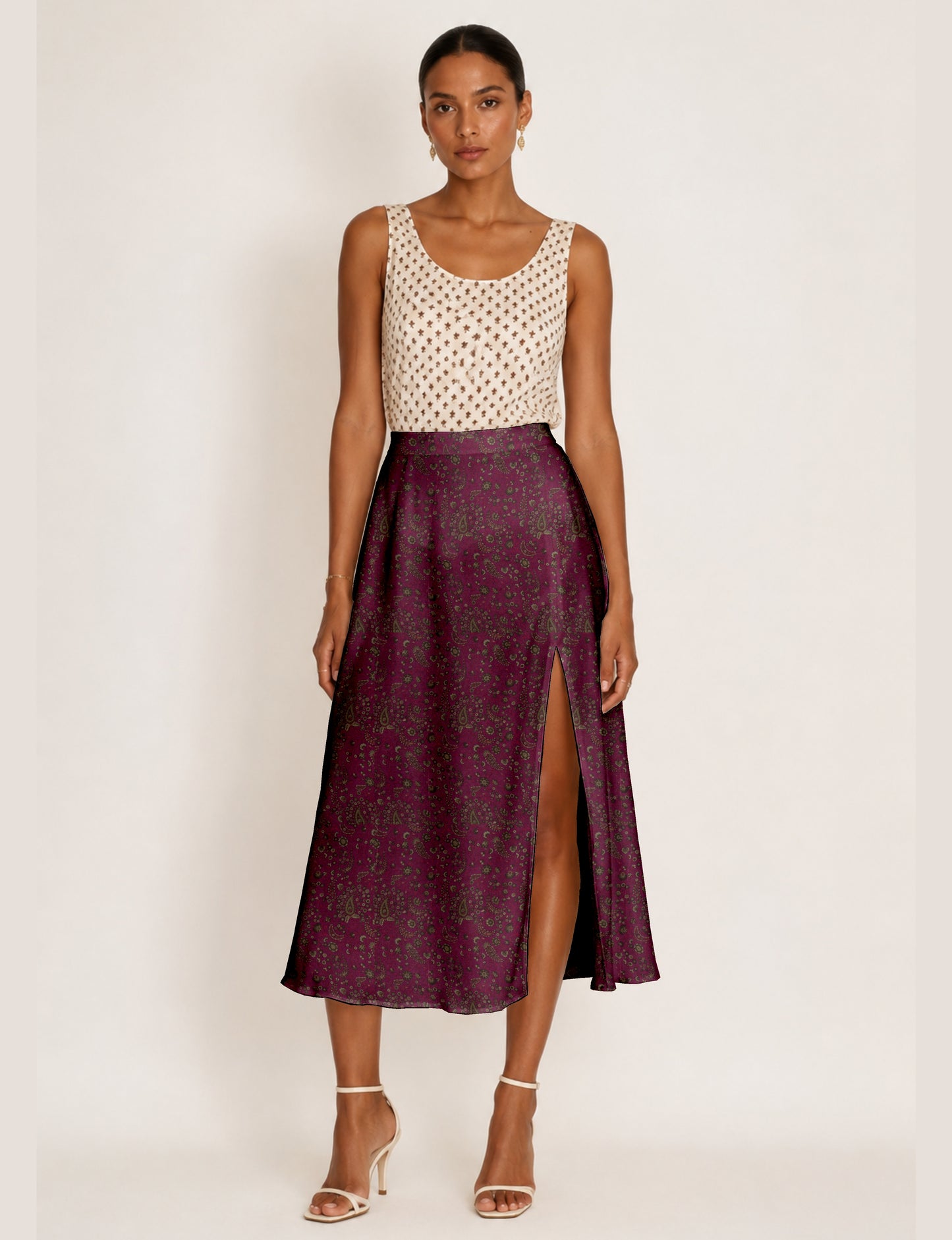 Woman wearing a yellow and navy blue A-line skirt with a slit and a sleeveless beige top with brown micro print