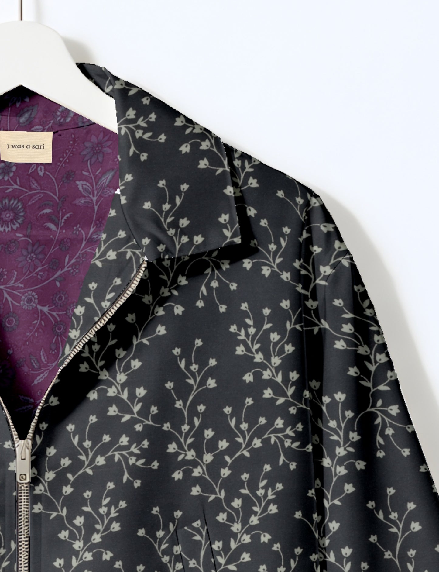 Women's cropped bomber jacket with twin metallic front zippers, welt pockets, elasticated hem and cuffs, and contrast sari print lining.