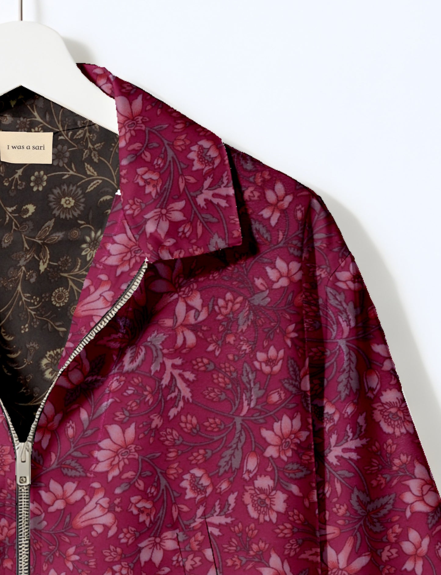 Women's cropped bomber jacket with twin metallic front zippers, welt pockets, elasticated hem and cuffs, and contrast sari print lining.