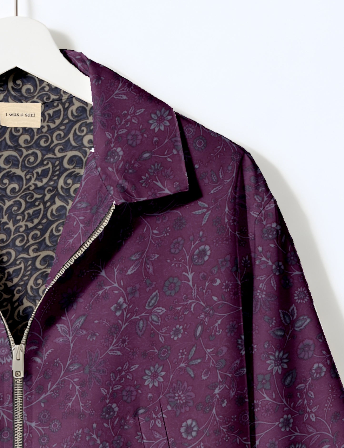 Women's cropped bomber jacket with twin metallic front zippers, welt pockets, elasticated hem and cuffs, and contrast sari print lining.