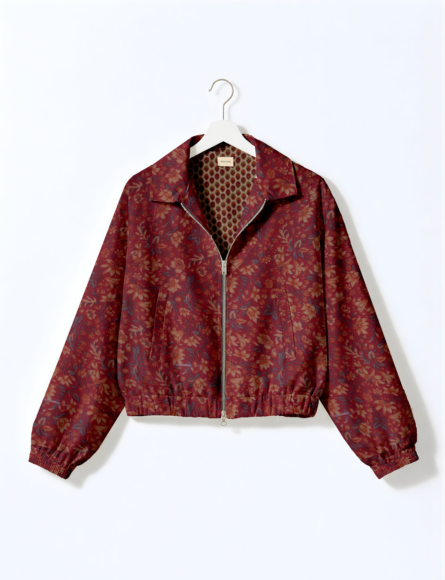 Pink floral bomber jacket with front zipper, elastic cuffs, and gathered waistband, shown on white hanger front view