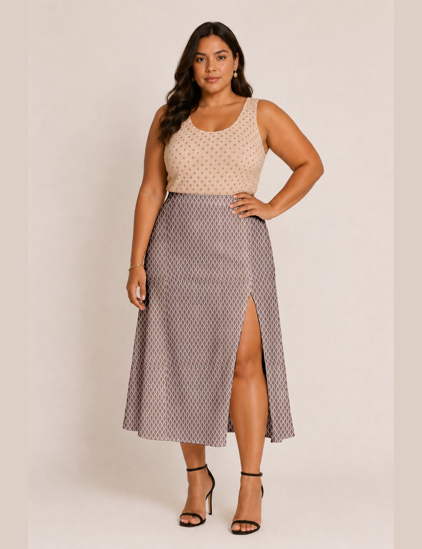 Woman wearing a yellow and black micro patterned A-line skirt with front slit, paired with beige sleeveless top and black