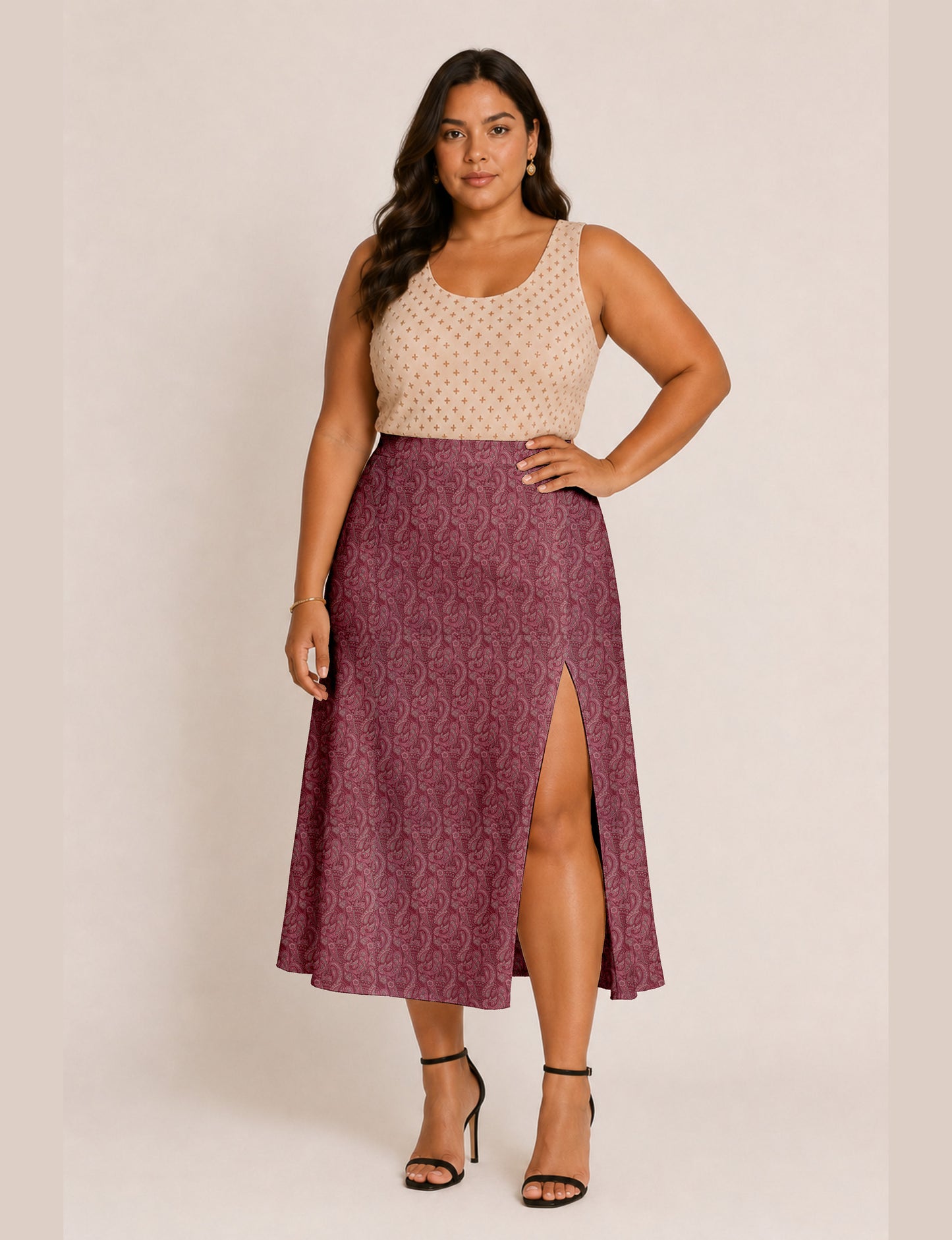 Woman wearing a yellow and black micro patterned A-line skirt with front slit, paired with beige sleeveless top and black