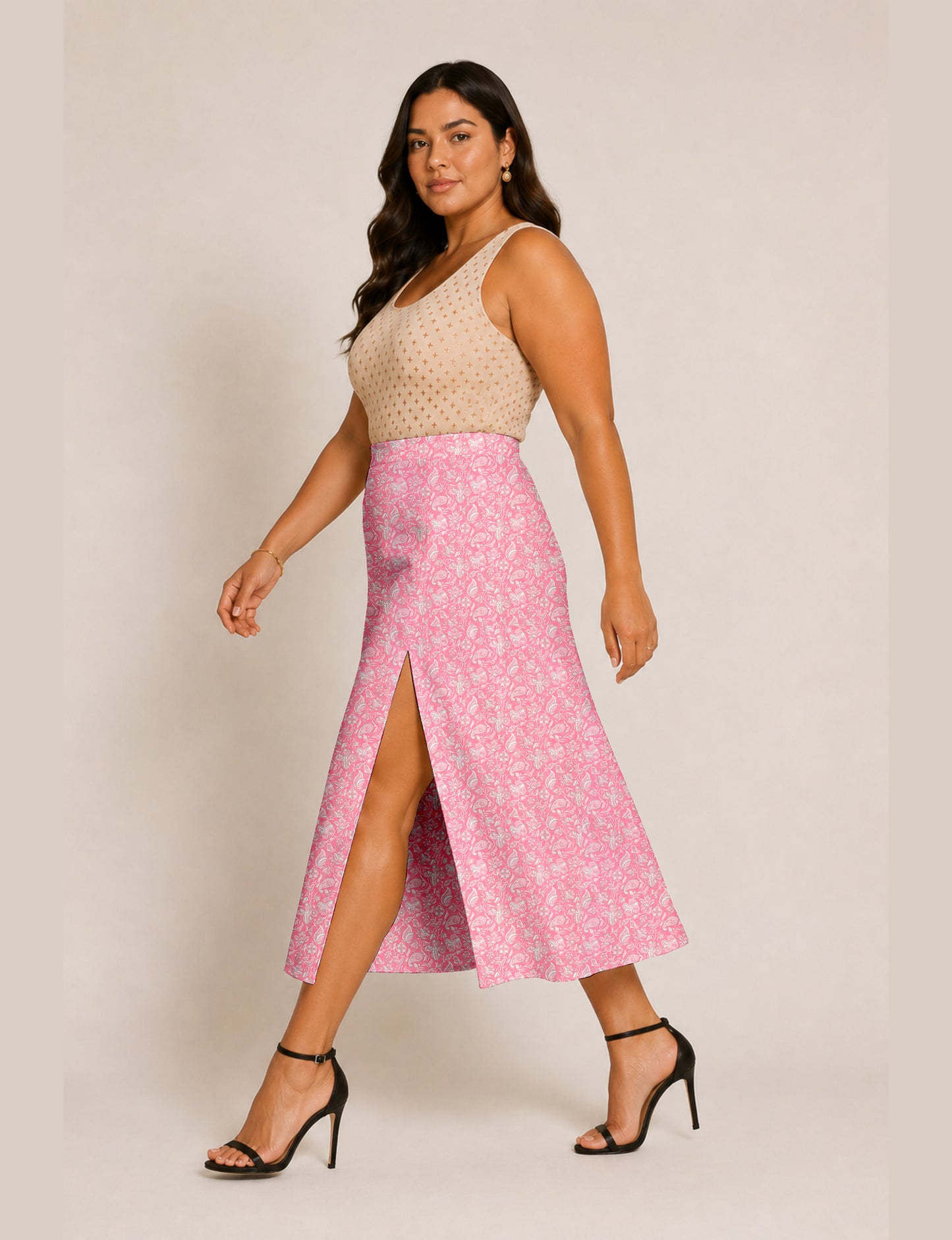 Woman wearing a yellow and black micro patterned A-line skirt with front slit, paired with beige sleeveless top and black