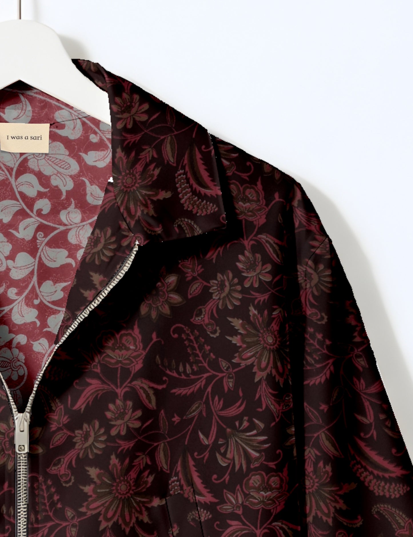 Women's cropped bomber jacket with twin metallic front zippers, welt pockets, elasticated hem and cuffs, and contrast sari print lining.