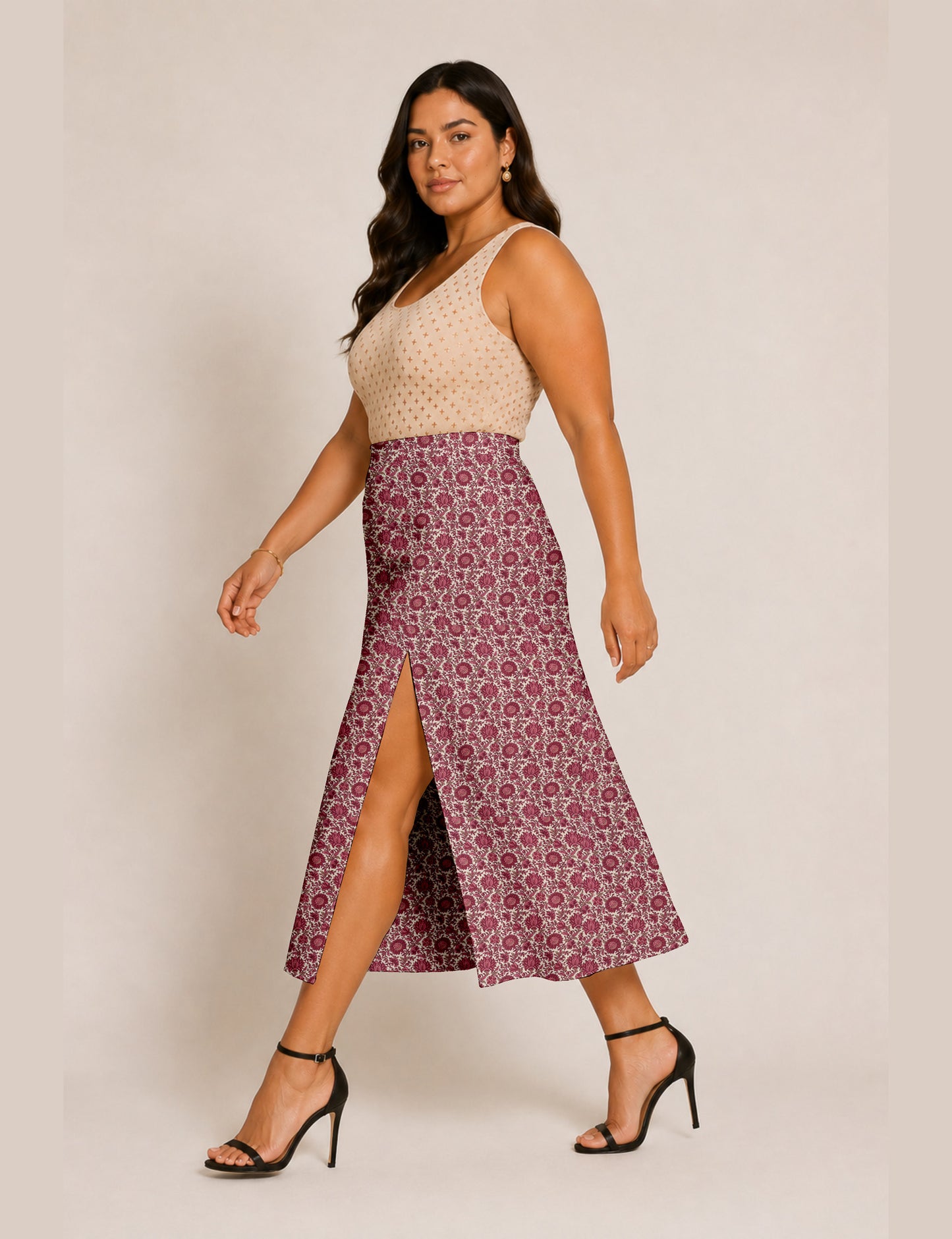 Woman wearing a yellow and black micro patterned A-line skirt with front slit, paired with beige sleeveless top and black