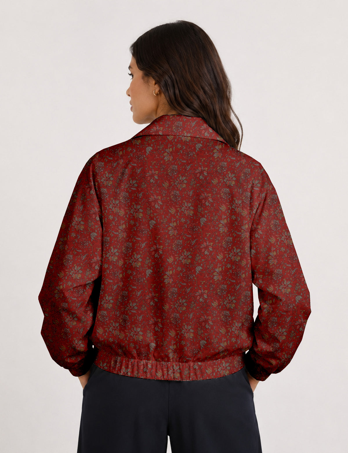 Woman wearing a yellow floral bomber jacket with front zipper, elastic cuffs, and side pockets, shown from front view