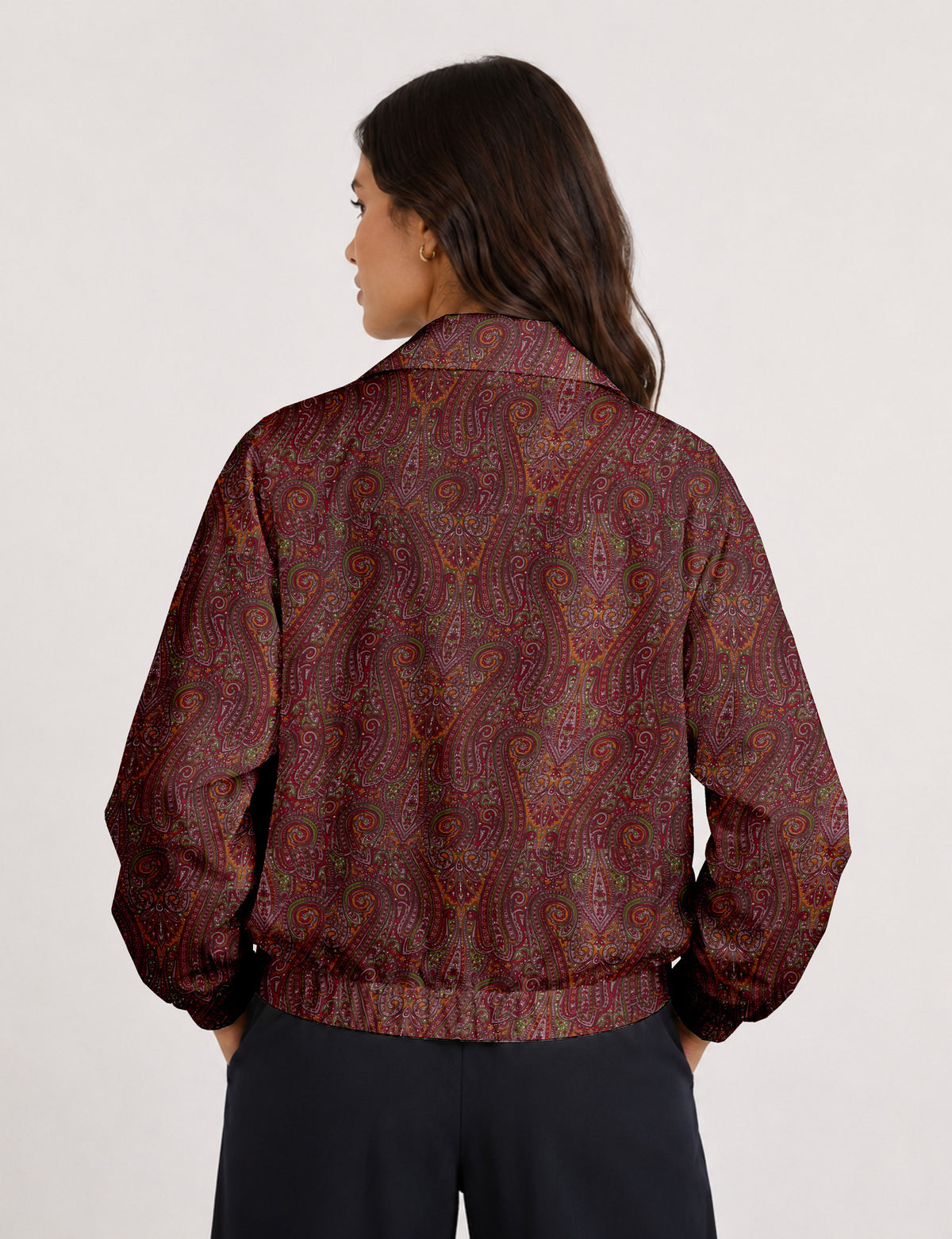 Woman wearing a yellow floral bomber jacket with front zipper, elastic cuffs, and side pockets, shown from front view