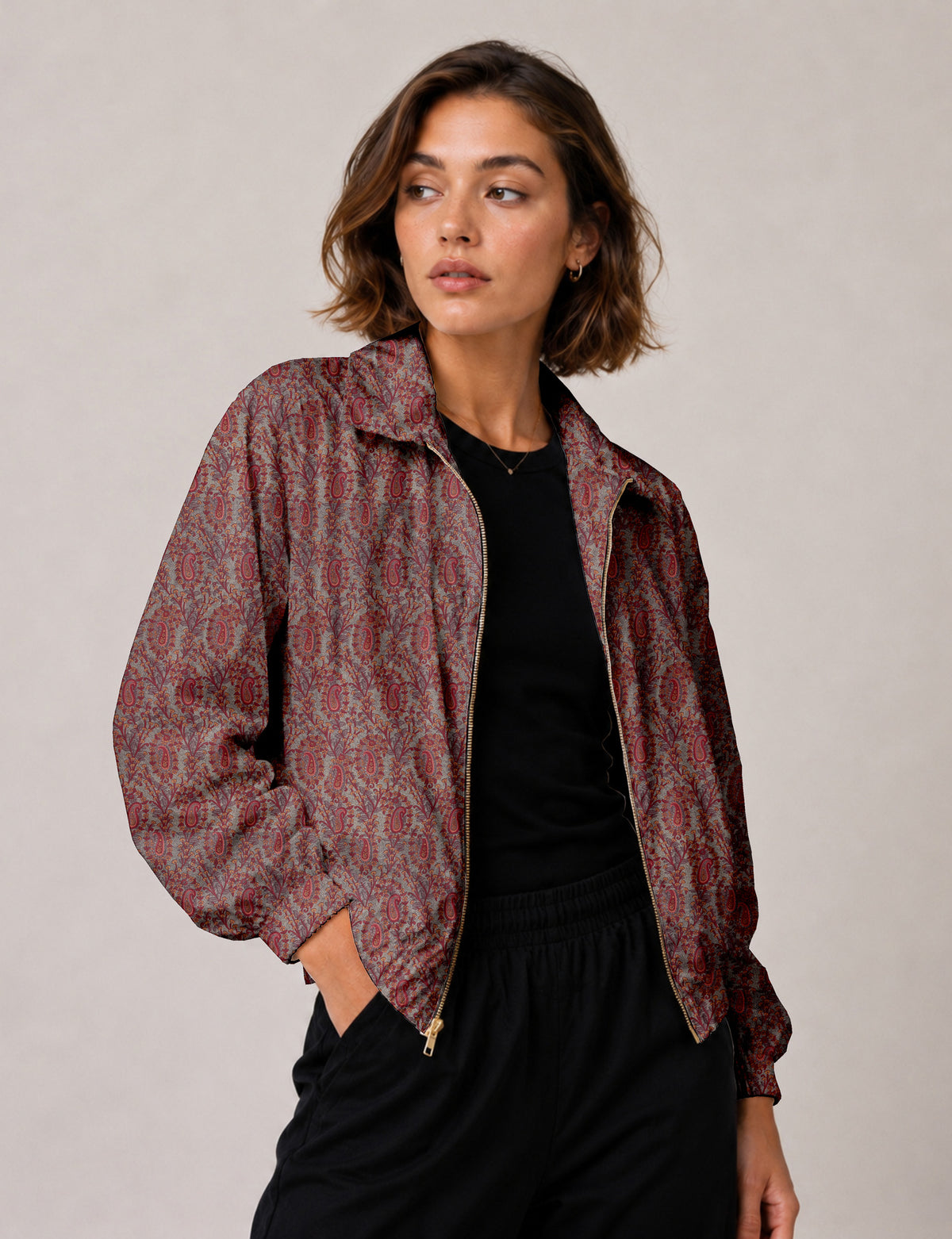 Brown floral bomber jacket with front zipper, elastic cuffs and hem, hanging on white hanger, red floral inner lining visible