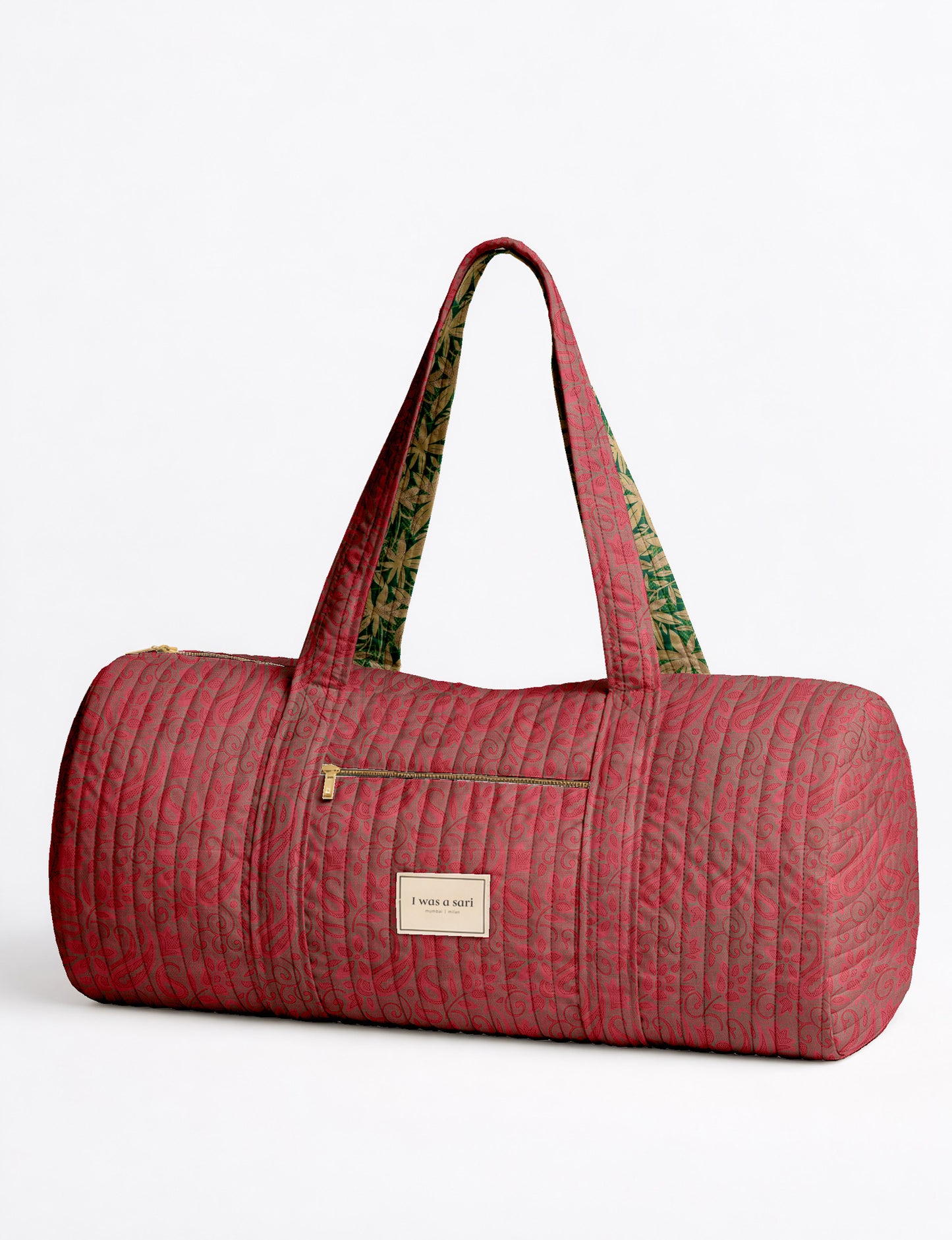 Brown paisley quilted bowling bag with front zipper pocket, held by person wearing white shirt and light blue jeans