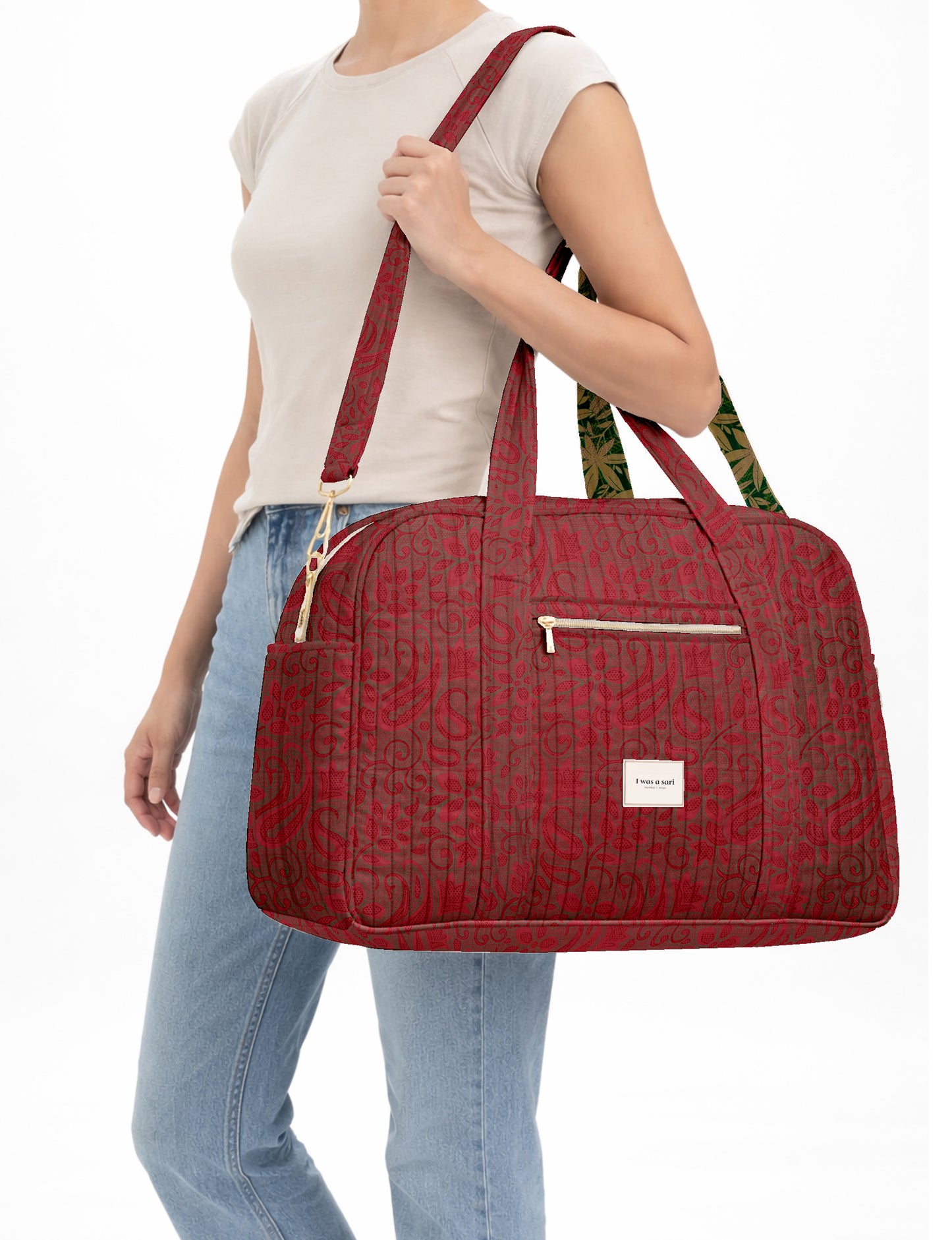 Brown quilted duffle bag with paisley pattern, front zip pocket, dual handles, and label reading "I was a sari"