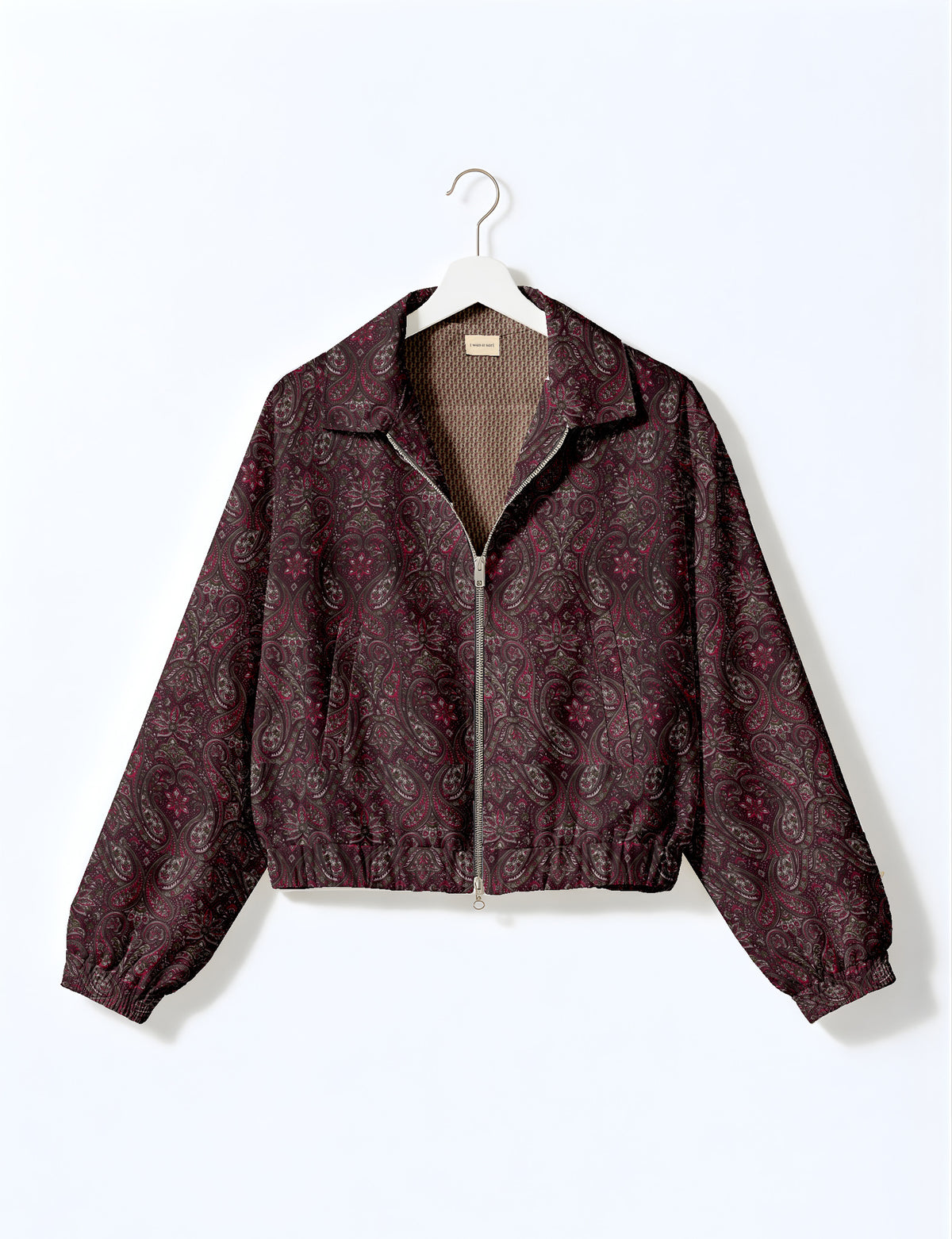 Brown floral bomber jacket with front zipper, elastic cuffs and hem, hanging on white hanger, red floral inner lining visible
