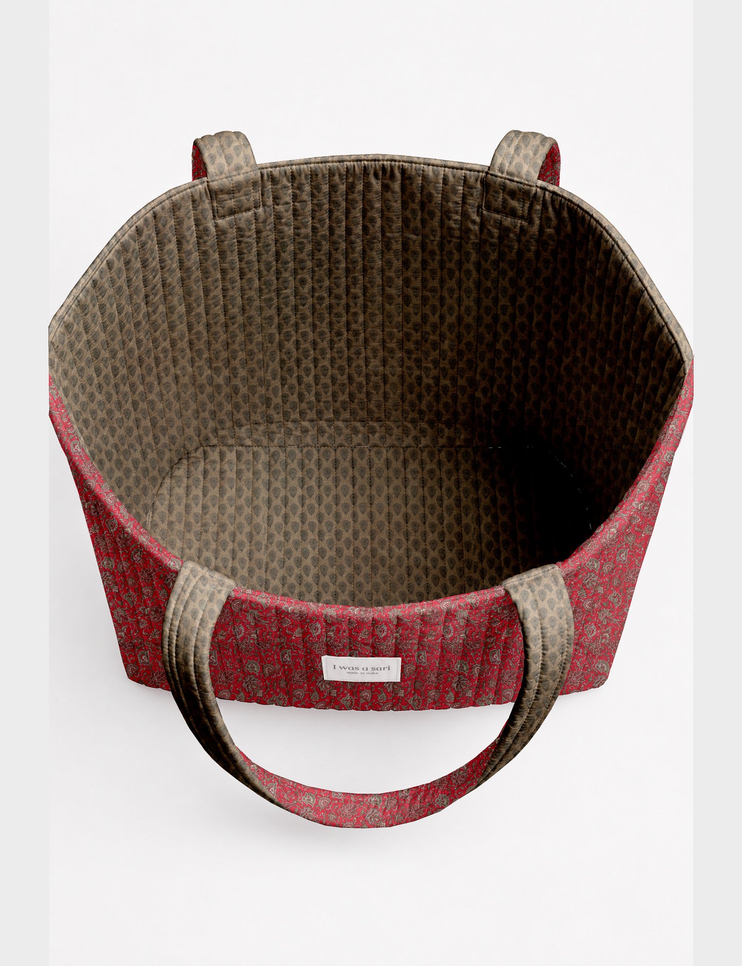 Quilted beach bag with yellow tropical exterior and red patterned interior, shown from top view with handles visible