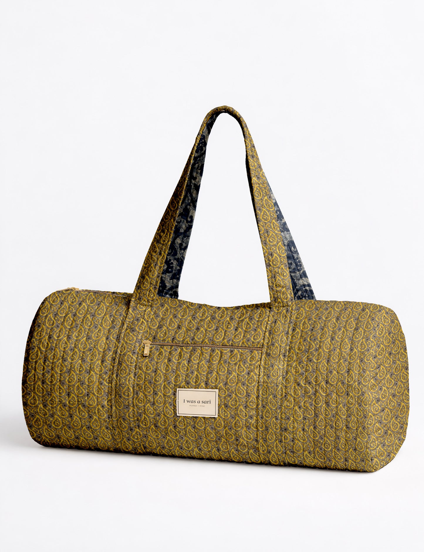 Brown paisley quilted bowling bag with dual handles, front zipper pocket, and "I was a sari" label on front side