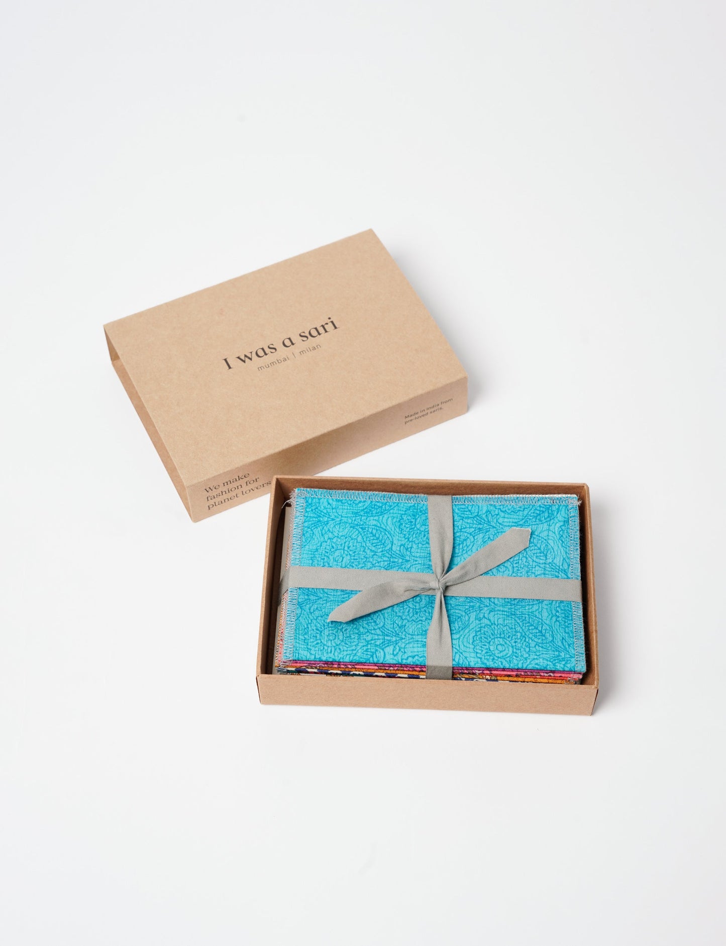 Sustainably crafted FOLDED POSTCARD SET, 10 assorted pieces made with 100% recycled paper and printed sari fabric sourced from Mumbai markets. Eco-friendly with contrast overlock edging. Envelopes included for eco-conscious gratitude and cheerful messages to loved ones.