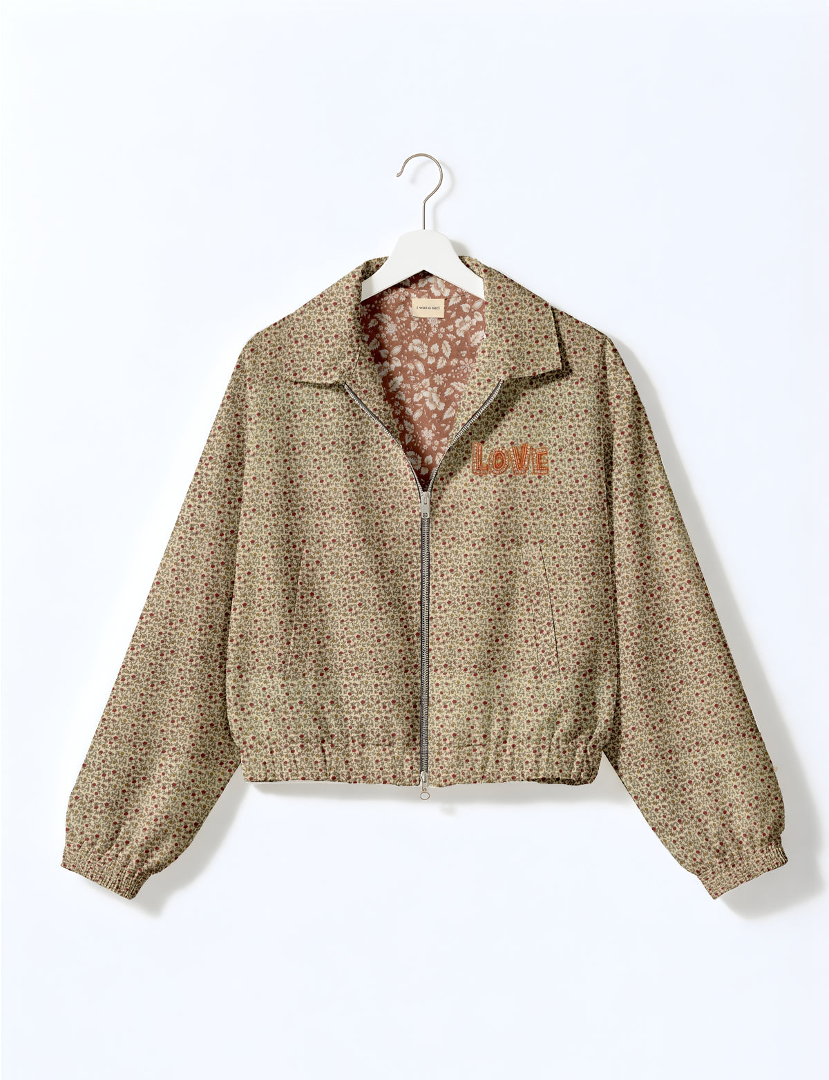 Beige floral bomber jacket with front zipper, elastic cuffs and hem, and "LOVE" embroidered on chest, shown on hanger