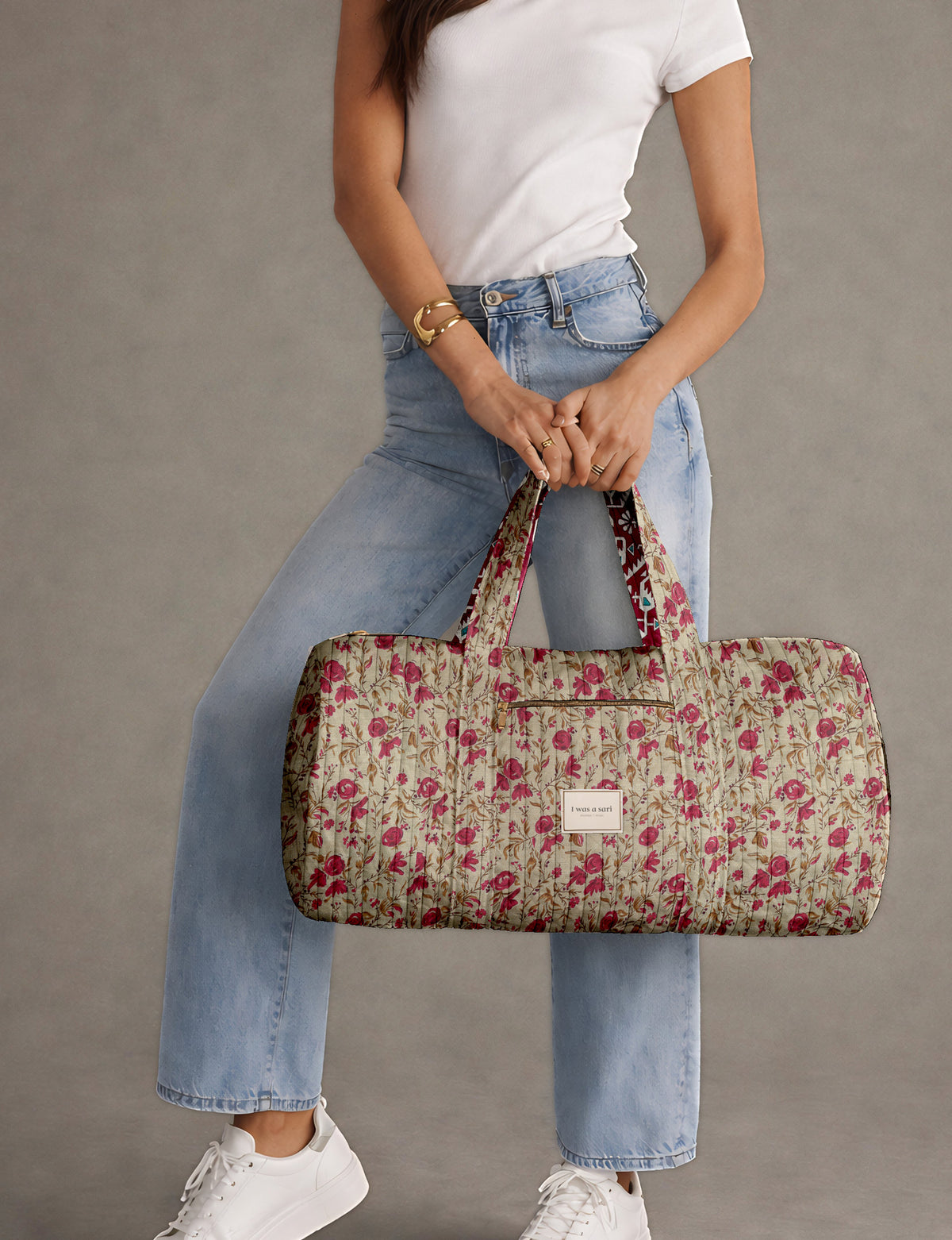 Brown paisley quilted bowling bag with dual handles, front zipper pocket, and "I was a sari" label on front side