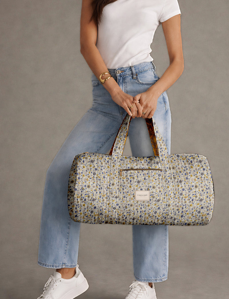 Brown paisley quilted bowling bag with dual handles, front zipper pocket, and "I was a sari" label on front side