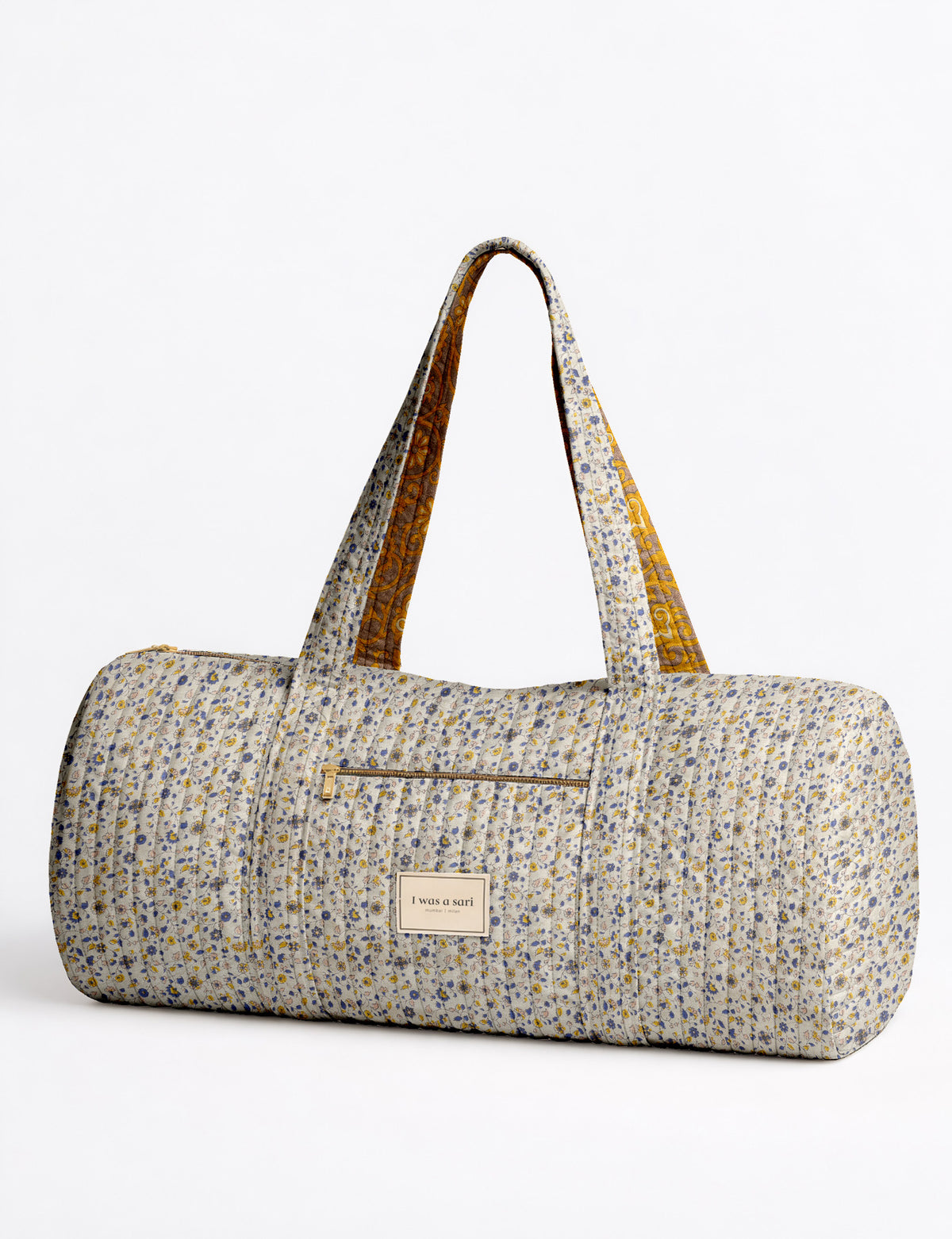 Brown paisley quilted bowling bag with dual handles, front zipper pocket, and "I was a sari" label on front side