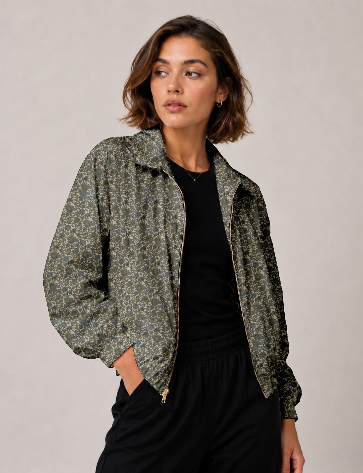 Brown floral bomber jacket with front zipper, elastic cuffs and hem, hanging on white hanger, red floral inner lining visible