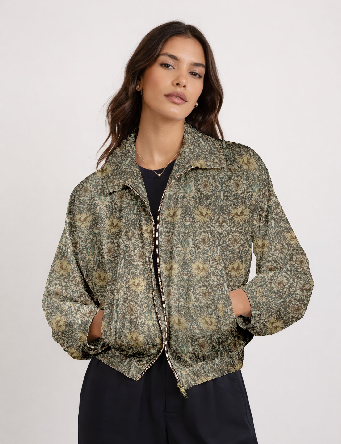 Woman wearing a yellow bomber jacket with a micro geometric pattern, front zipper, and side pockets, paired with black pants