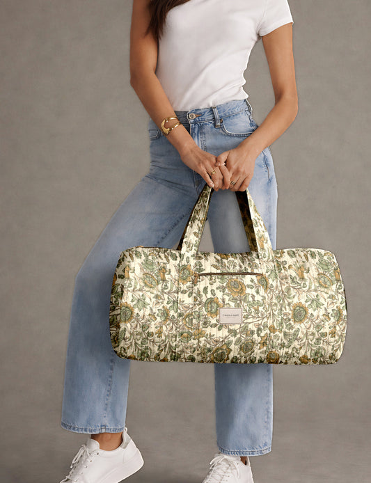 Brown paisley quilted bowling bag with dual handles, front zipper pocket, and "I was a sari" label on front side