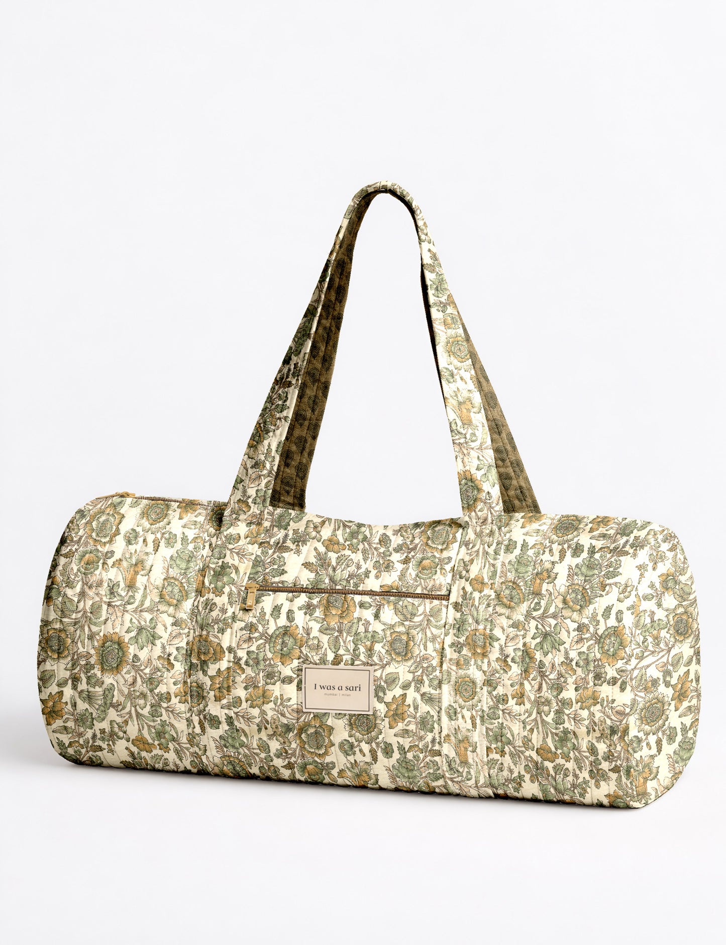 Brown paisley quilted bowling bag with front zipper pocket, held by person wearing white shirt and light blue jeans