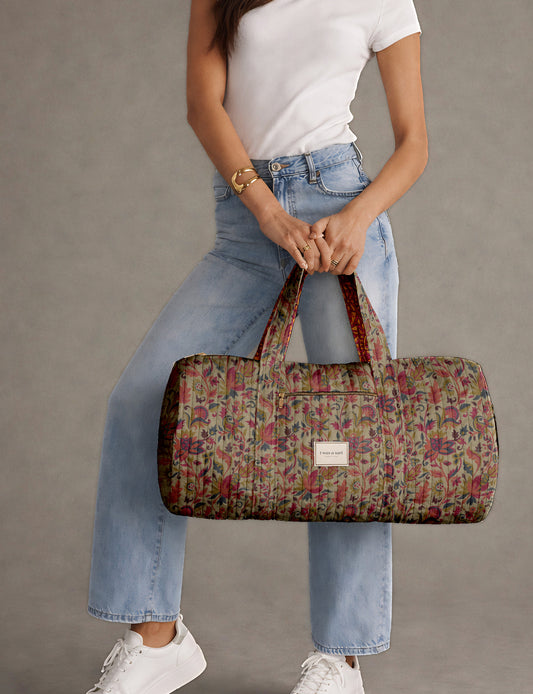 Brown paisley quilted bowling bag with dual handles, front zipper pocket, and "I was a sari" label on front side
