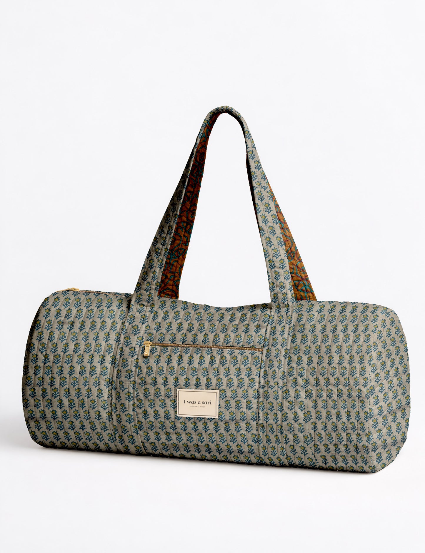 Brown paisley quilted bowling bag with dual handles, front zipper pocket, and "I was a sari" label on front side