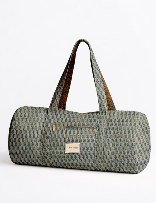 Brown paisley quilted bowling bag with dual handles, front zipper pocket, and "I was a sari" label on front side