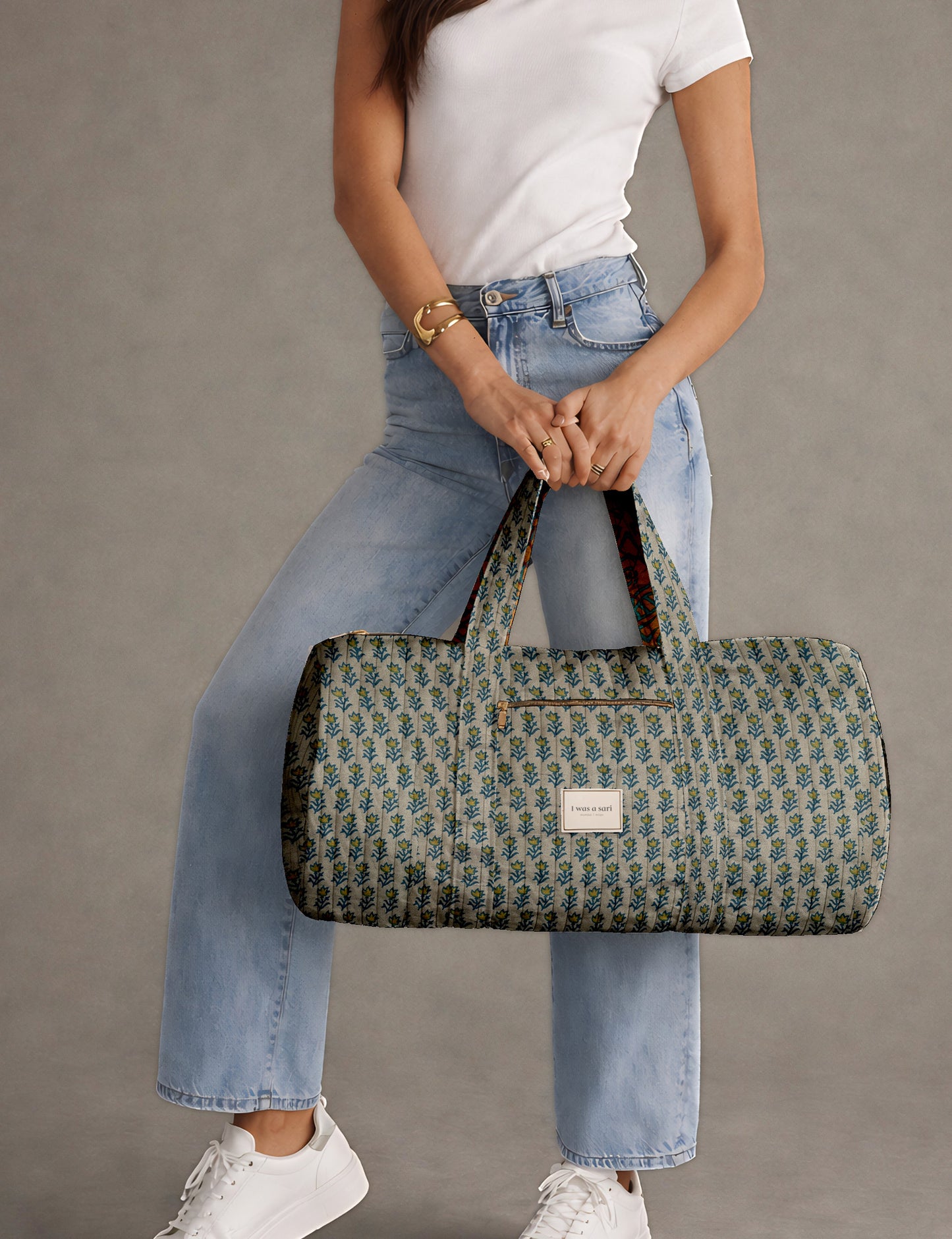 Brown paisley quilted bowling bag with dual handles, front zipper pocket, and "I was a sari" label on front side