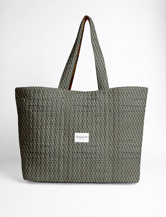 Quilted yellow tropical patterned beach bag with long handles and white label reading "I was a sari" front view