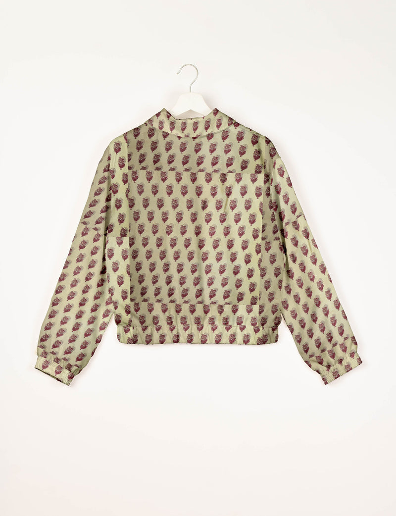 Beige bomber jacket with maroon leaf pattern, elastic cuffs, and back view on white hanger against white background