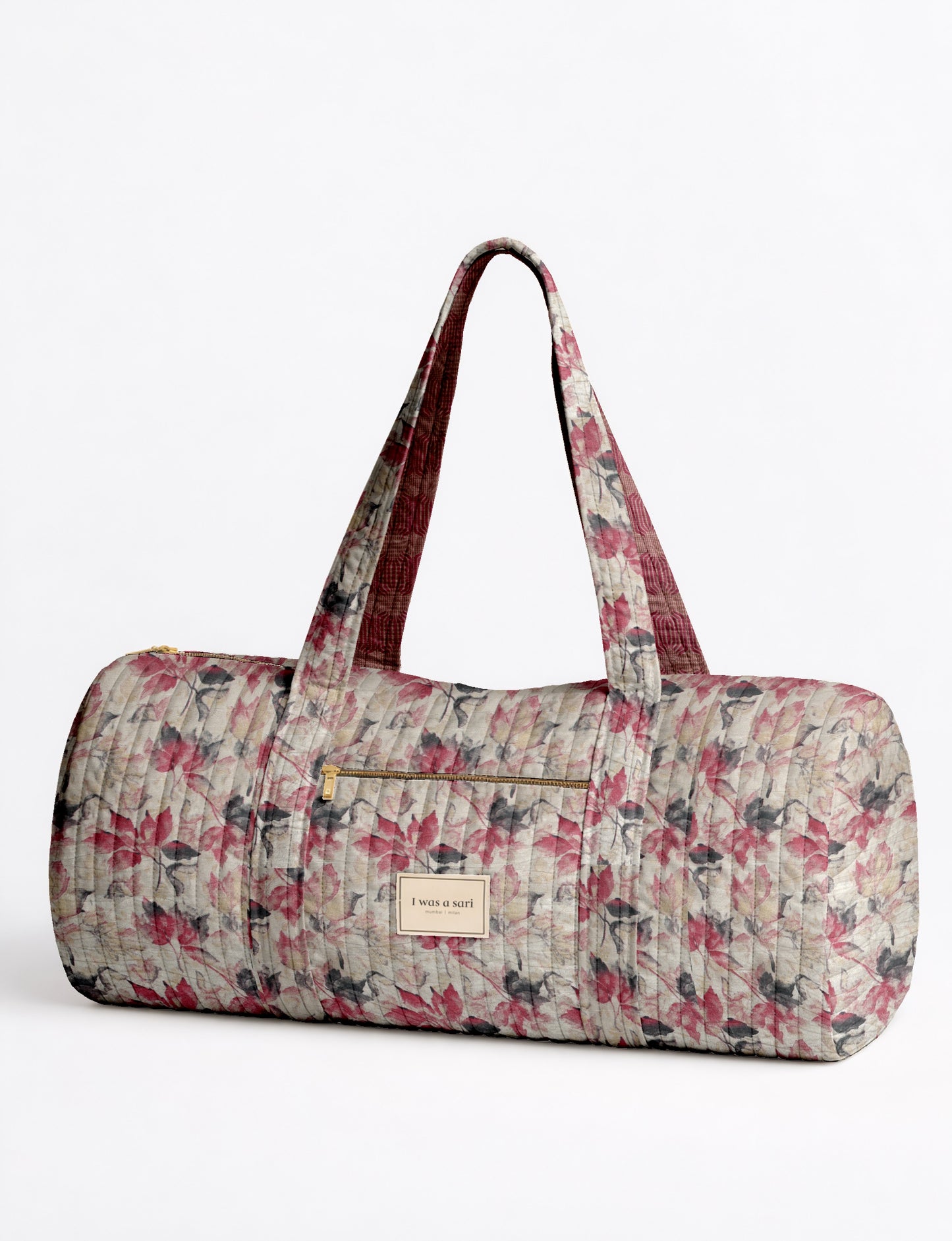 Beige quilted bowling bag with micro floral pattern, front zipper pocket, and dual handles with striped inner lining