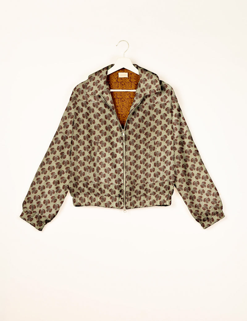 Beige bomber jacket with brown leaf pattern, front zipper, elastic cuffs and hem, shown hanging on white hanger