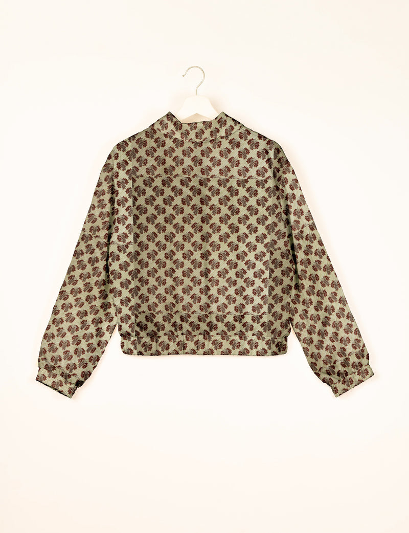 Beige bomber jacket with brown leaf pattern, long sleeves, elastic cuffs and waistband, shown from back on hanger