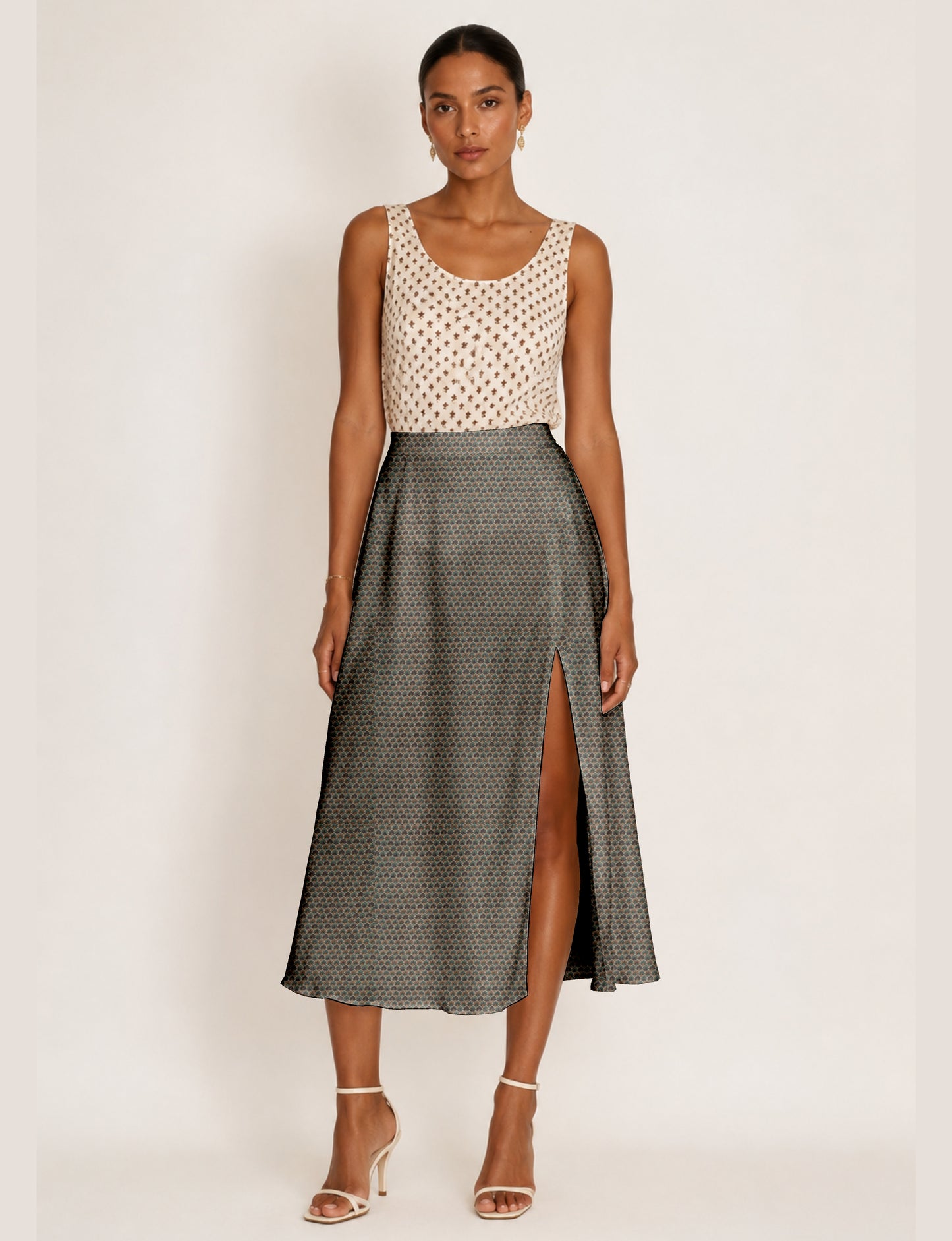 Woman wearing a yellow and black micro patterned A-line skirt with front slit, paired with beige sleeveless top and black