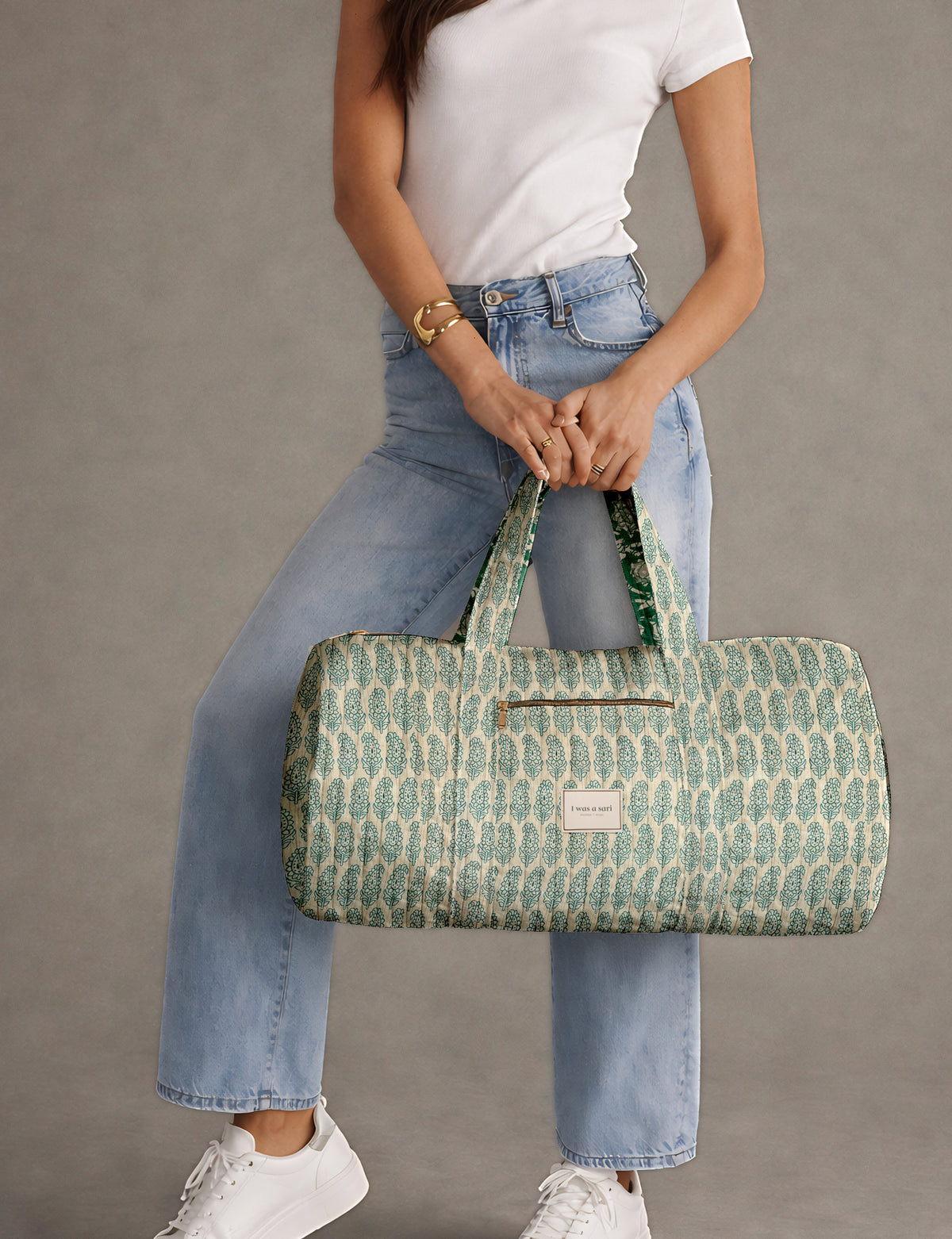 Brown paisley quilted bowling bag with dual handles, front zipper pocket, and "I was a sari" label on front side